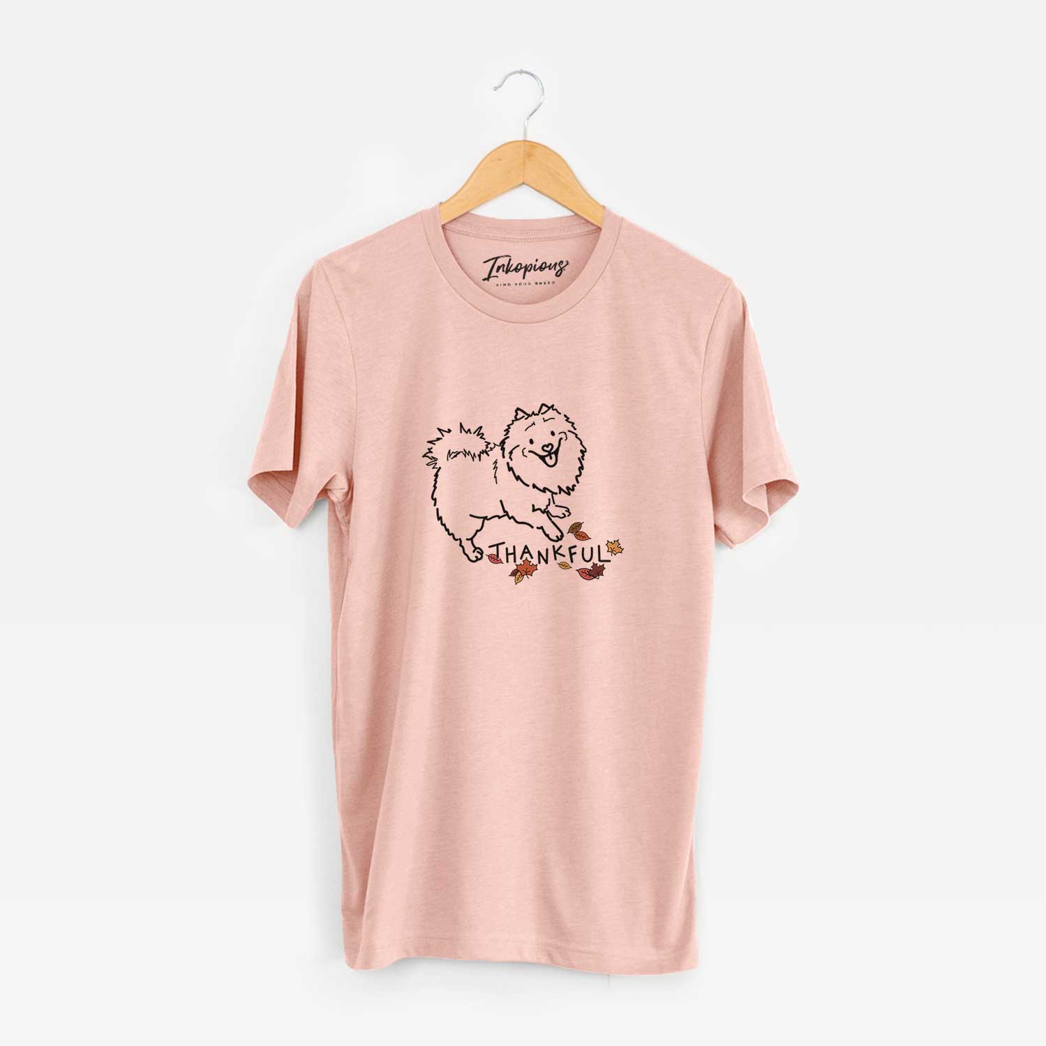Minimalist line drawing of Goldie the Pomeranian Mix with 'Thankful' lettering on a Peach Unisex crewneck