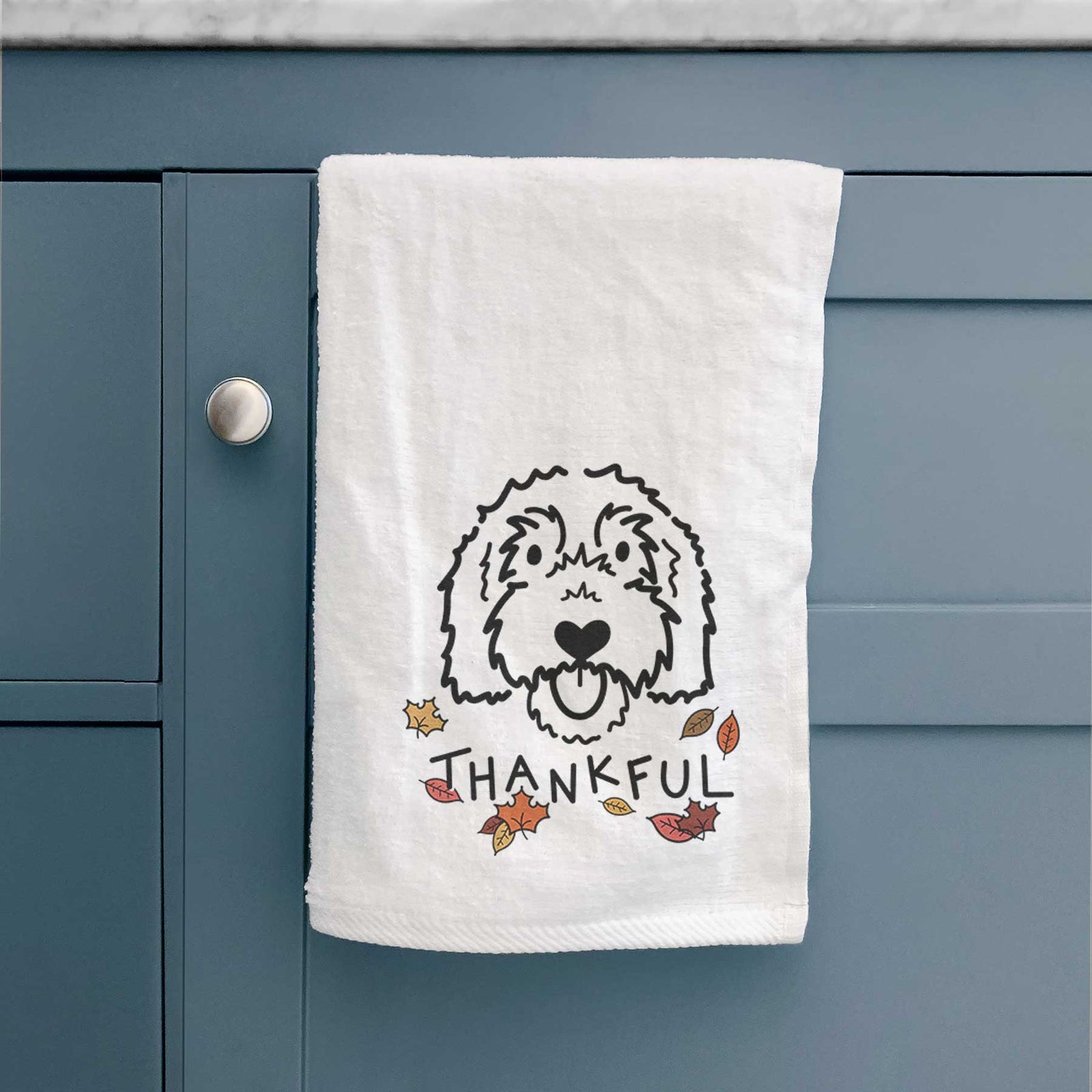 Minimalist line drawing of Gus the Goldendoodle with 'Thankful' lettering on a decorative hand towel