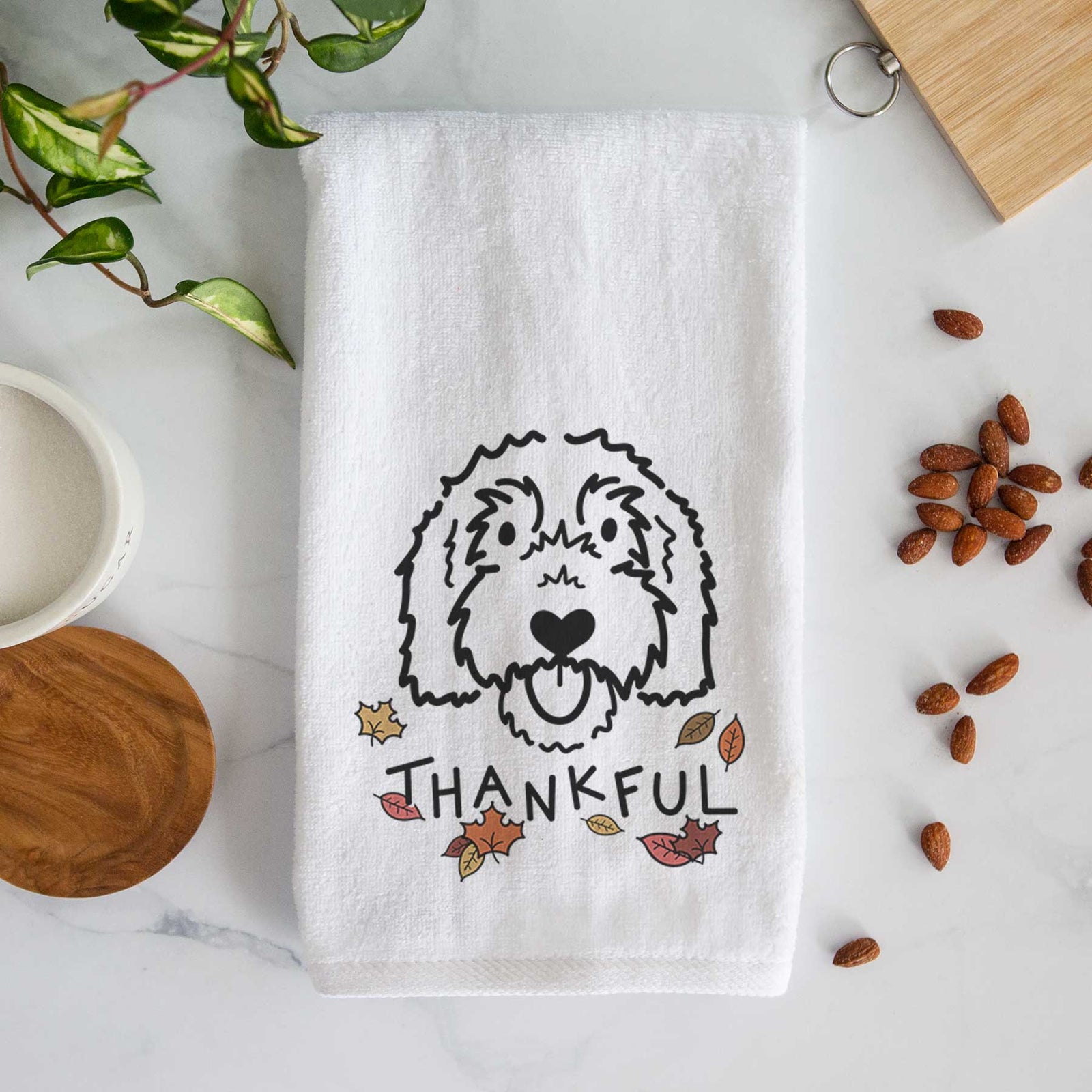 Minimalist line drawing of Gus the Goldendoodle with 'Thankful' lettering on a decorative hand towel