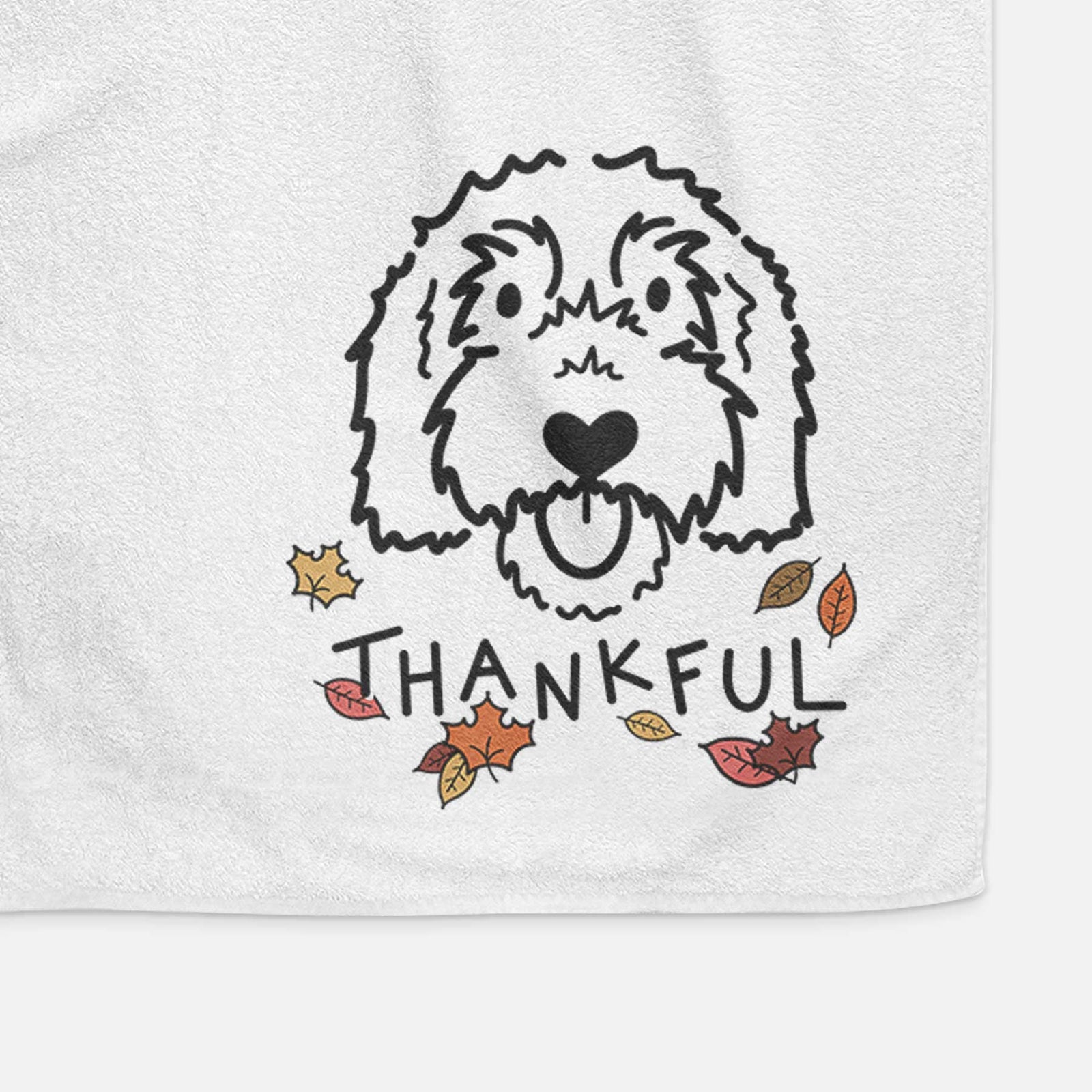 Minimalist line drawing of Gus the Goldendoodle with 'Thankful' lettering on a decorative hand towel