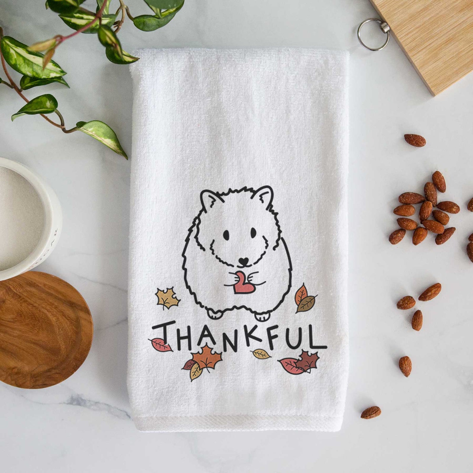 Minimalist line drawing of Hilga the Hamster with 'Thankful' lettering on a decorative hand towel