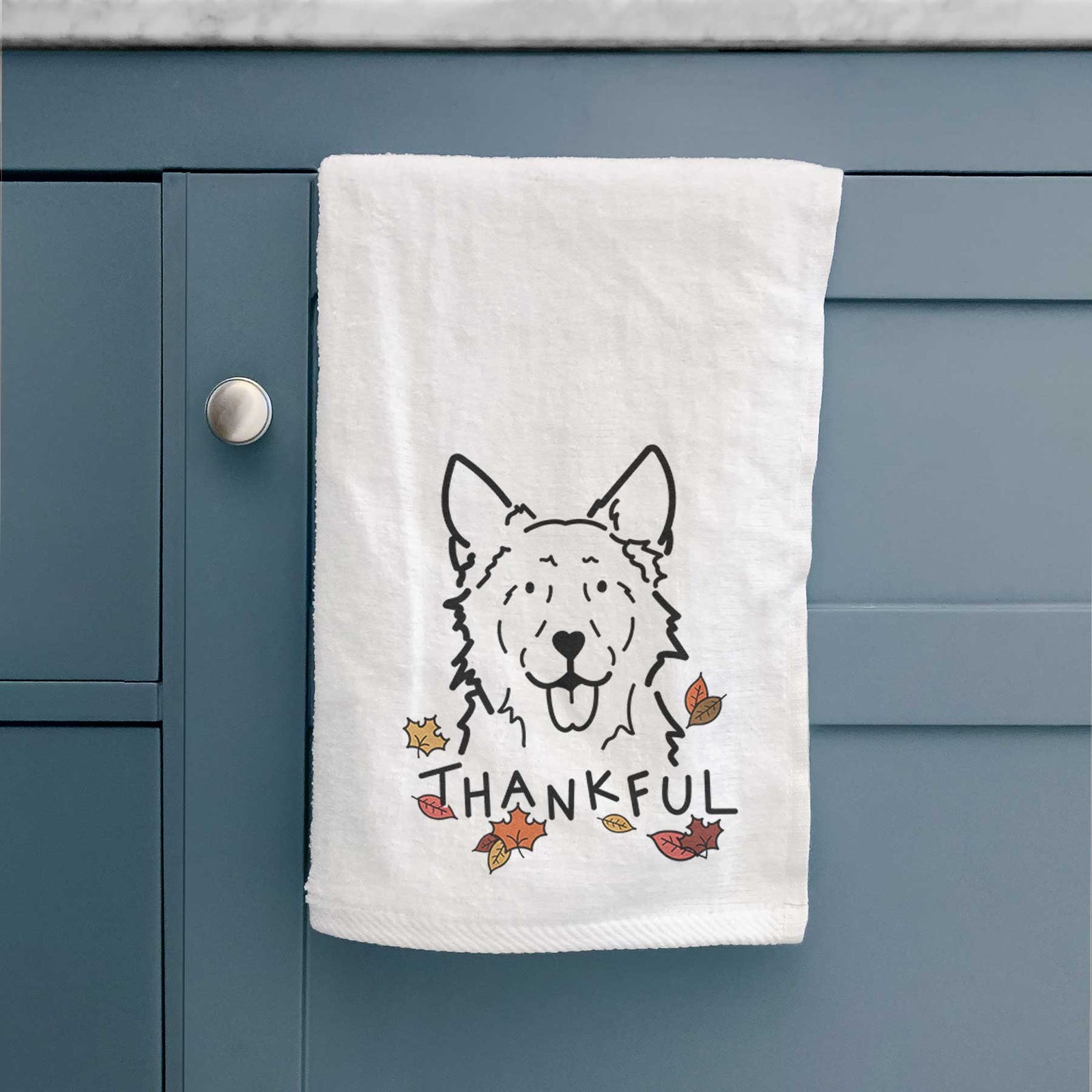 Minimalist line drawing of Jack the Mudi with 'Thankful' lettering on a decorative hand towel