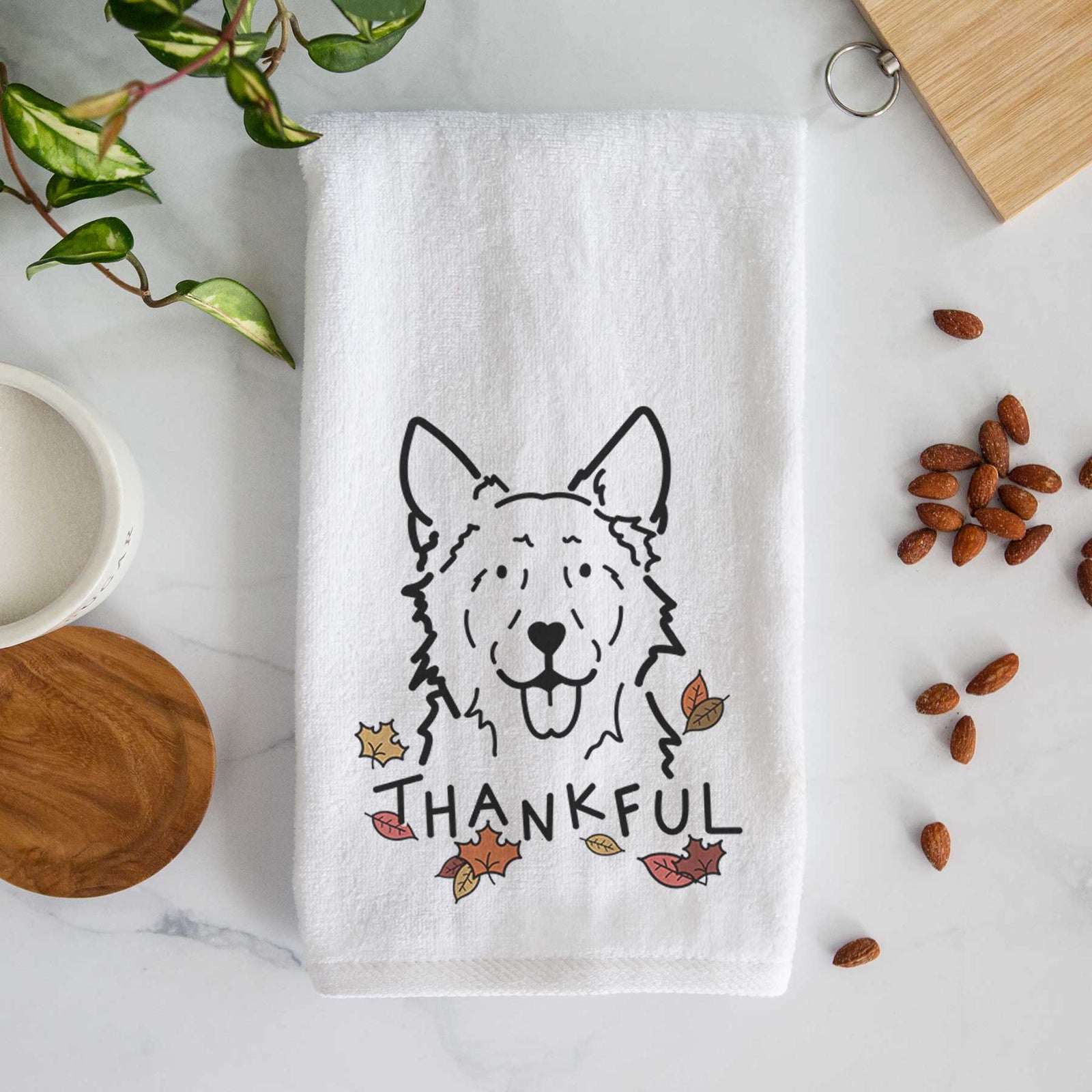Minimalist line drawing of Jack the Mudi with 'Thankful' lettering on a decorative hand towel