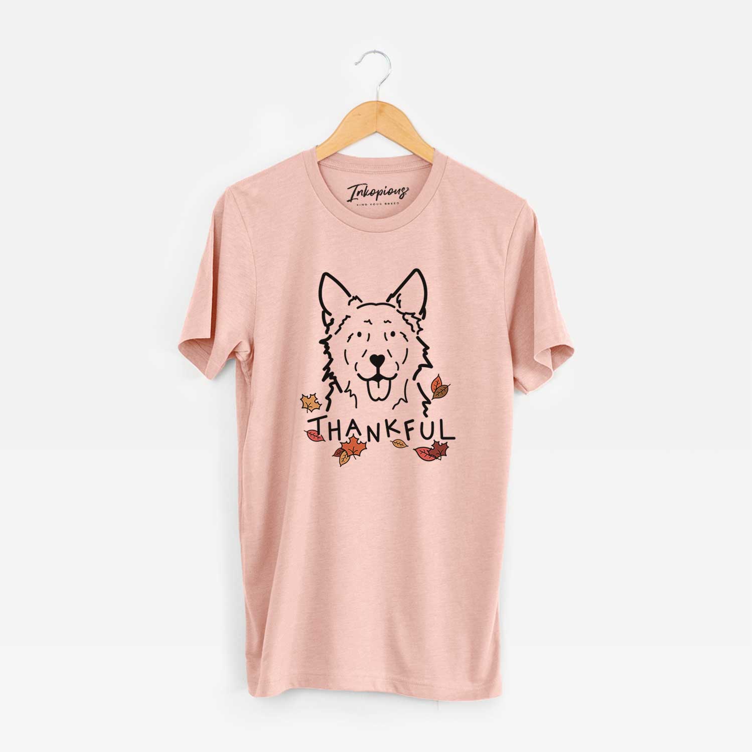 Minimalist line drawing of Jack the Mudi with 'Thankful' lettering on a Peach Unisex crewneck