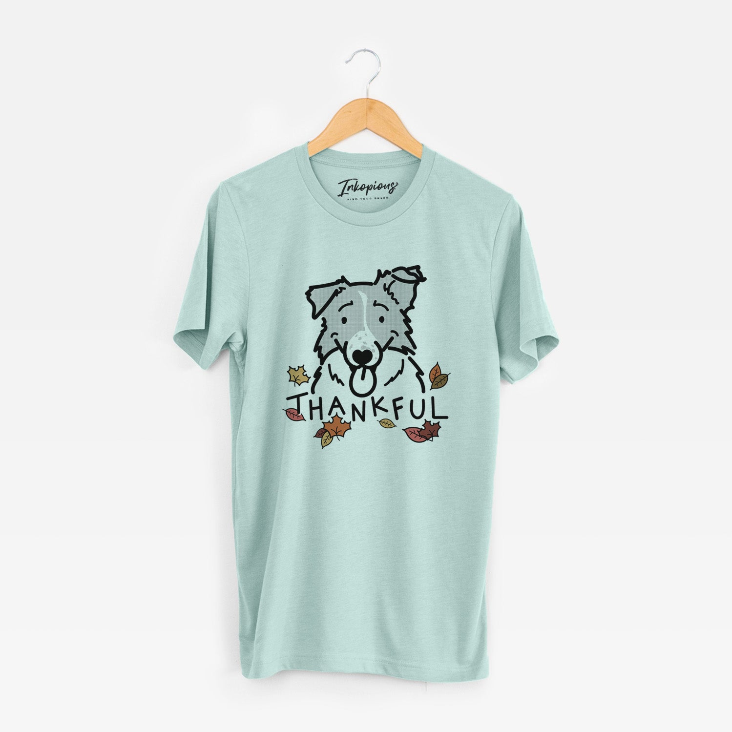 Minimalist line drawing of Jam the Border Collie with 'Thankful' lettering on a Heather Sage Unisex crewneck