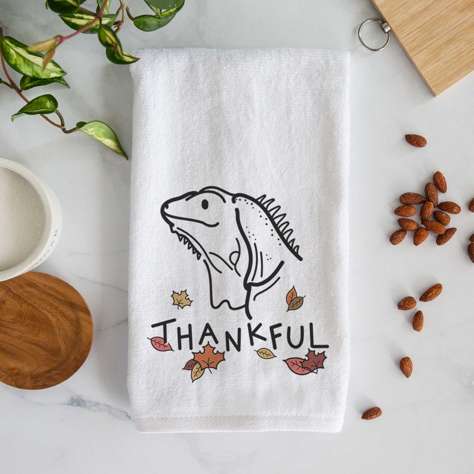 Minimalist line drawing of Louie the Iguana with 'Thankful' lettering on a decorative hand towel