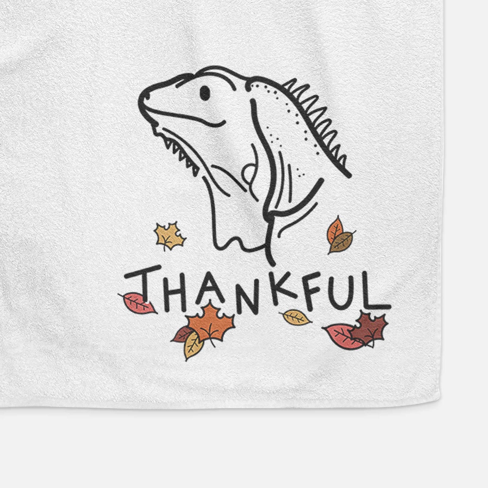 Minimalist line drawing of Louie the Iguana with 'Thankful' lettering on a decorative hand towel