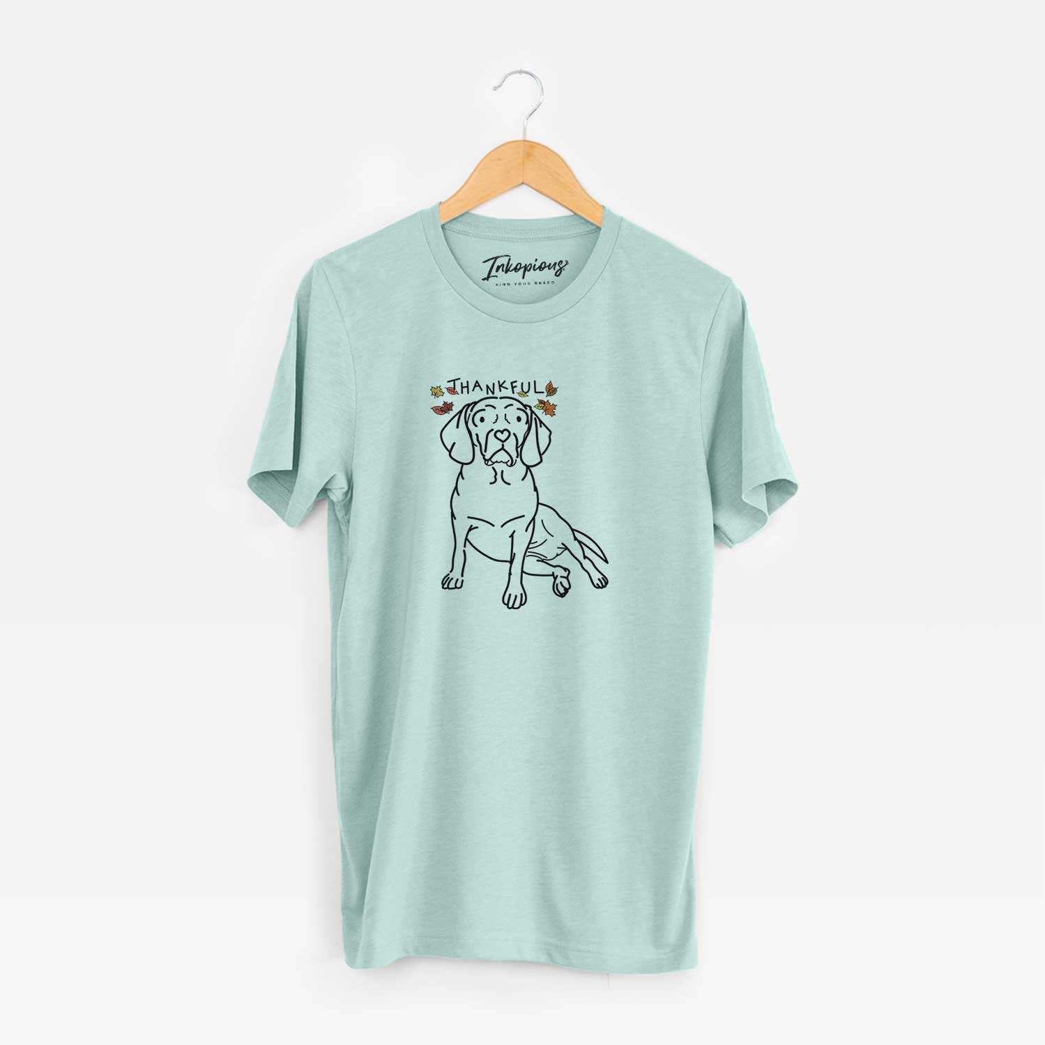 Minimalist line drawing of Mayble the Puggle with 'Thankful' lettering on a Heather Sage Unisex crewneck
