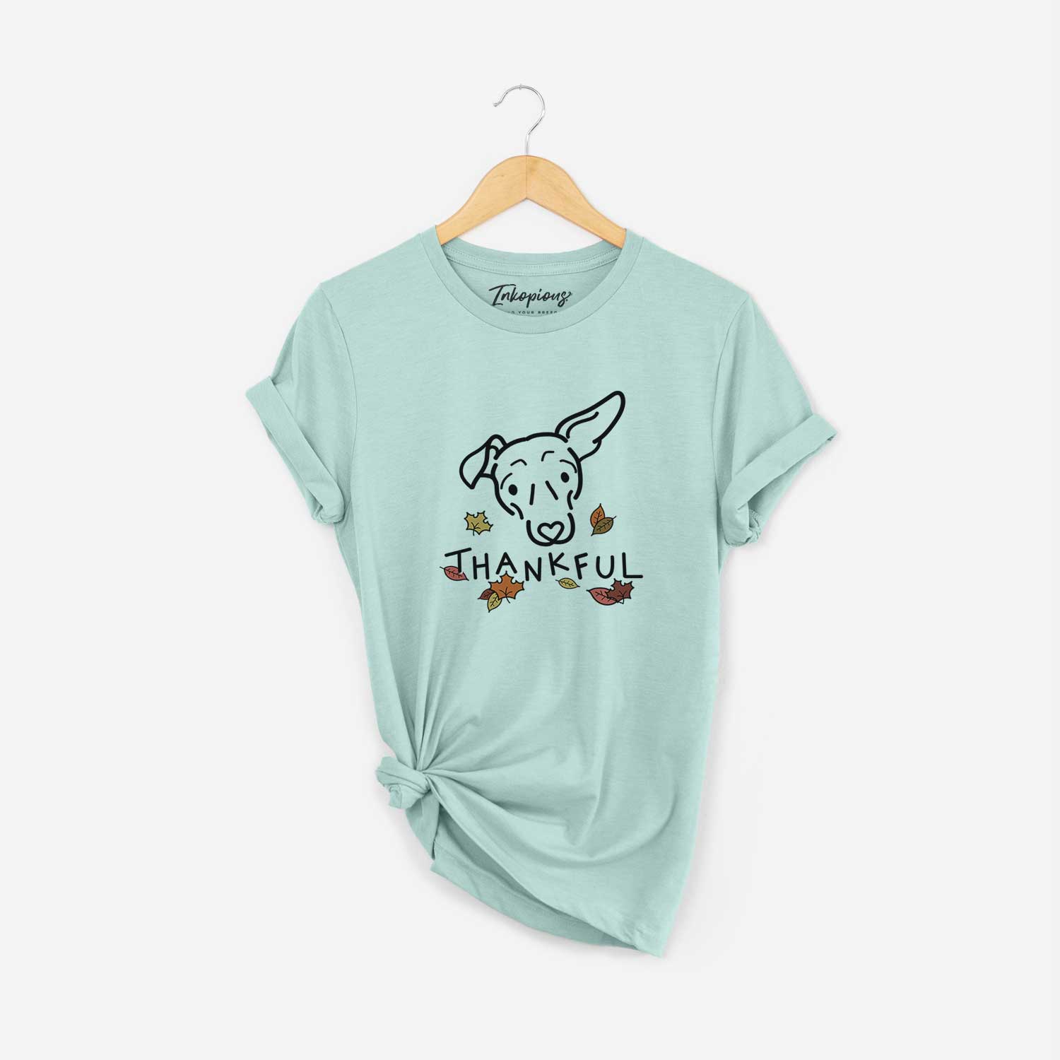 Minimalist line drawing of Millie the Mixed Breed with 'Thankful' lettering on a Heather Sage Unisex crewneck