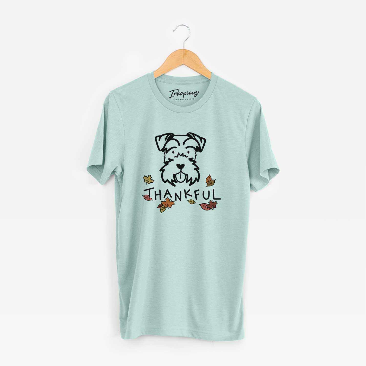 Minimalist line drawing of a Miniature Schnauzer with 'Thankful' lettering on a Heather Sage Unisex crewneck