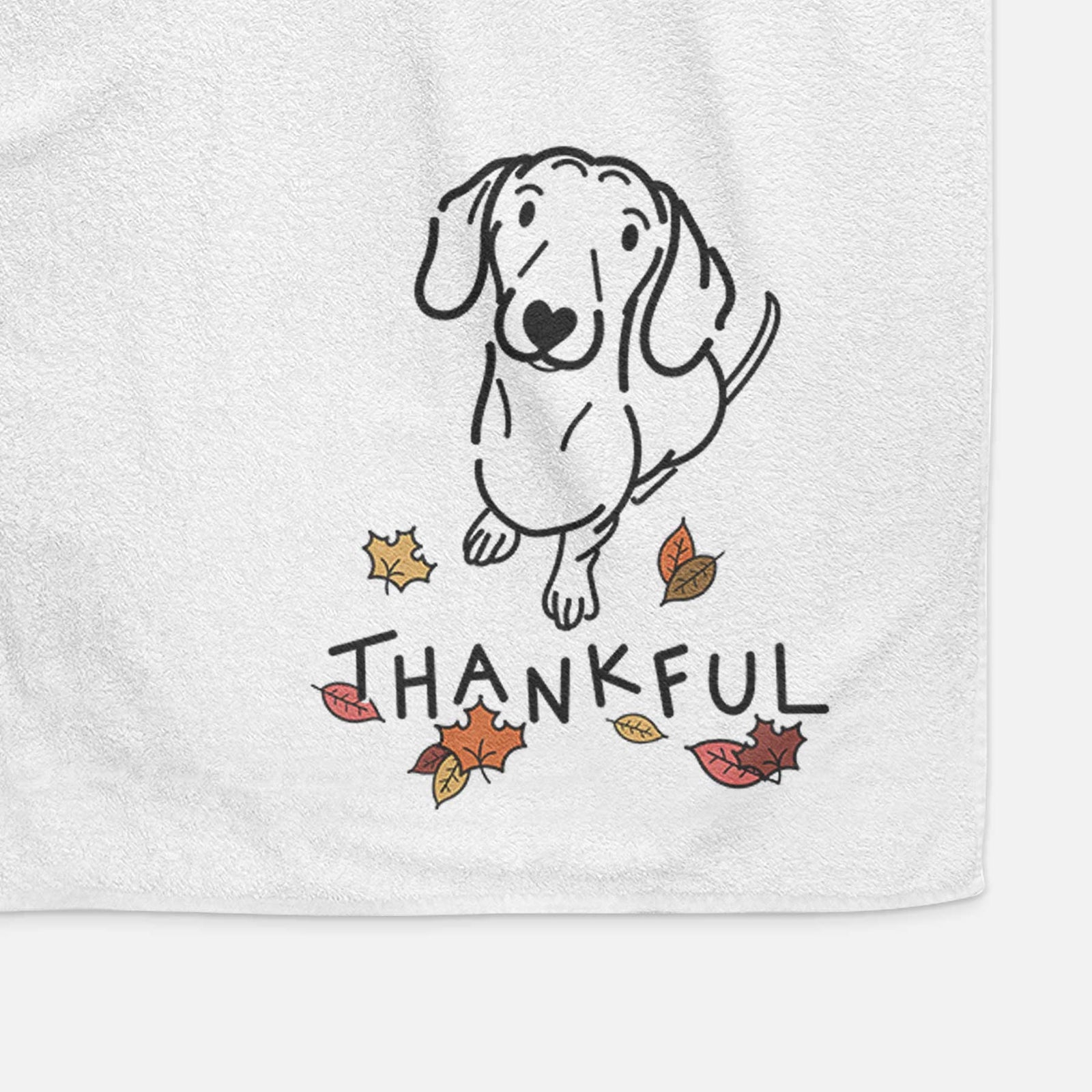 Minimalist line drawing of Moxie the Dachshund with 'Thankful' lettering on a decorative hand towel