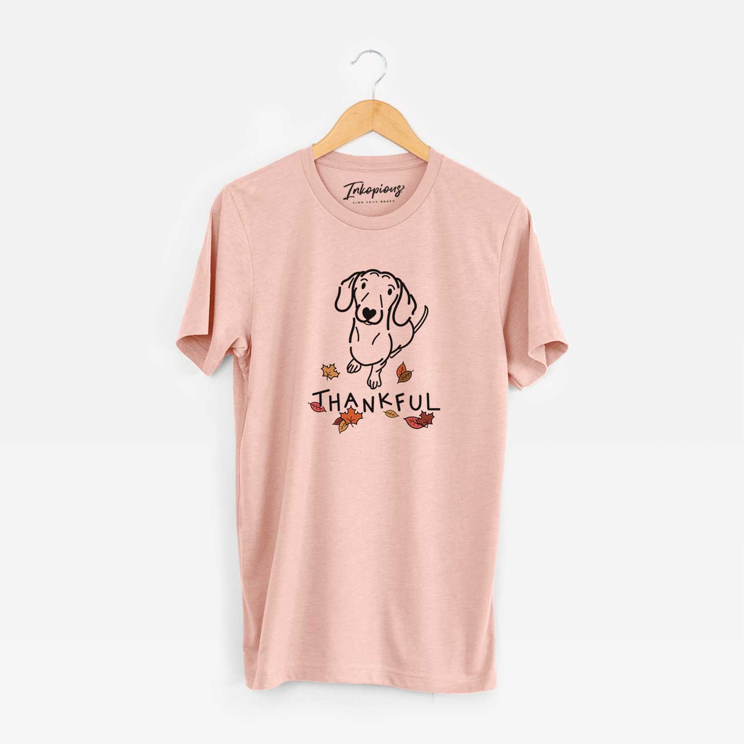 Minimalist line drawing of Moxie the Dachshund with 'Thankful' lettering on a Peach Unisex crewneck
