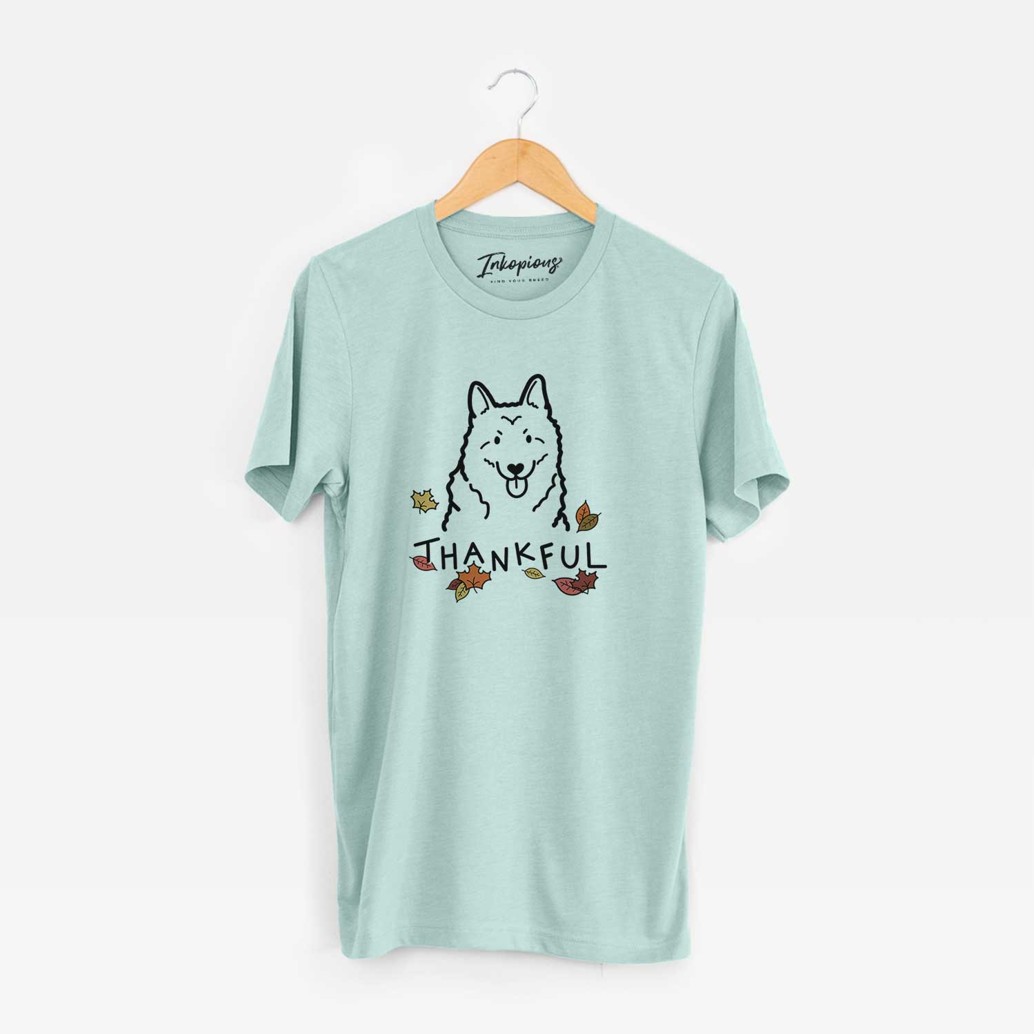 Minimalist line drawing of a Norwegian Elkhound with 'Thankful' lettering on a Heather Sage Unisex crewneck