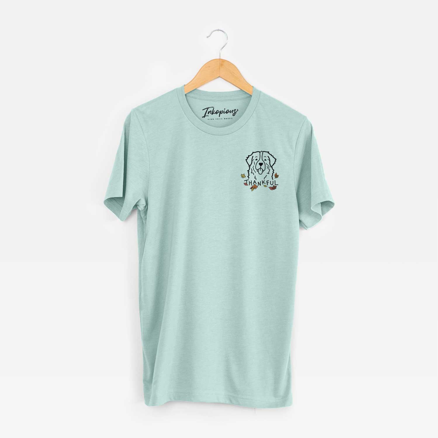 Small chest-pocket minimalist line drawing of a Bernese Mountain Dog with 'Thankful' lettering on a Heather Sage Unisex crewneck