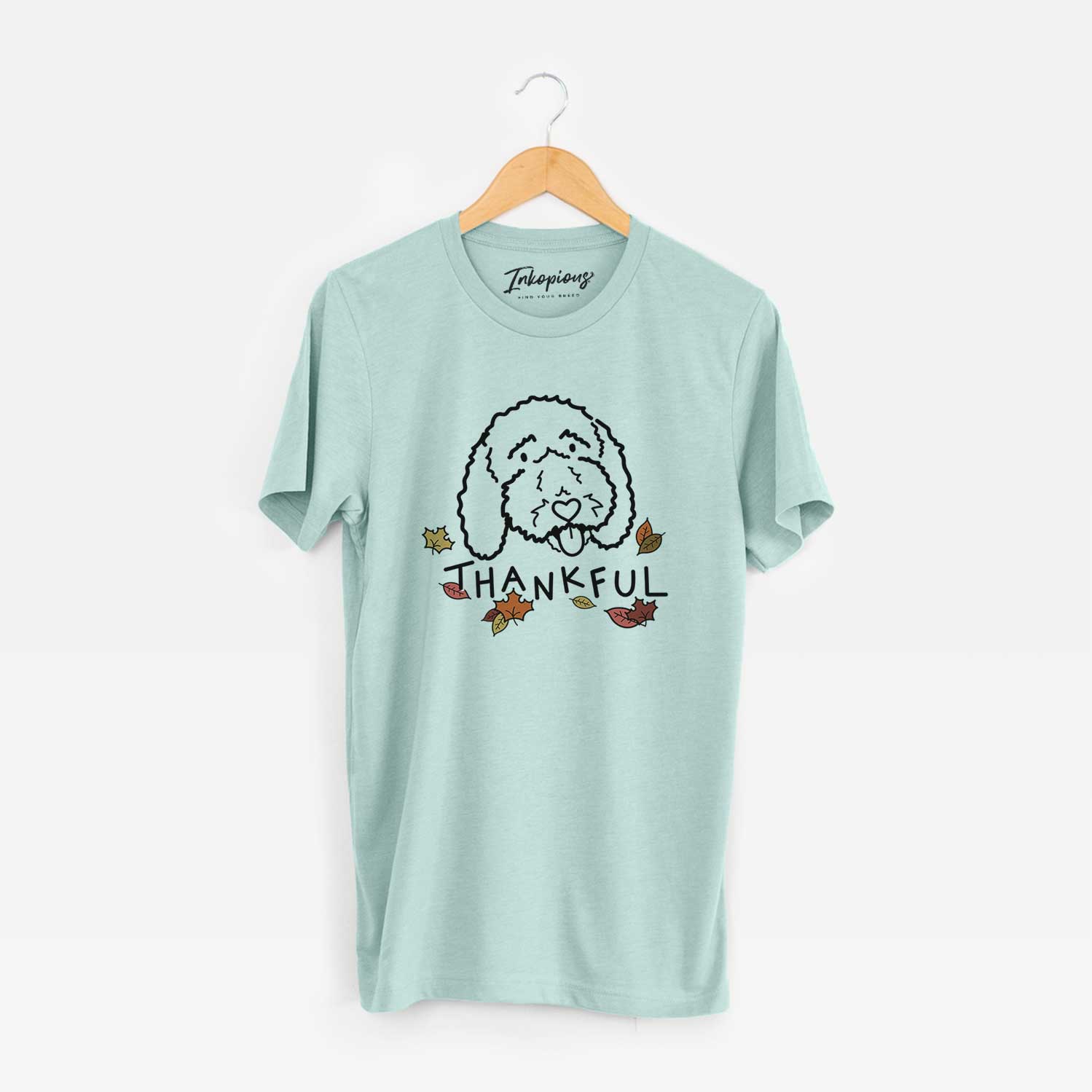Minimalist line drawing of Ruby the Bernedoodle with 'Thankful' lettering on a Heather Sage Unisex crewneck