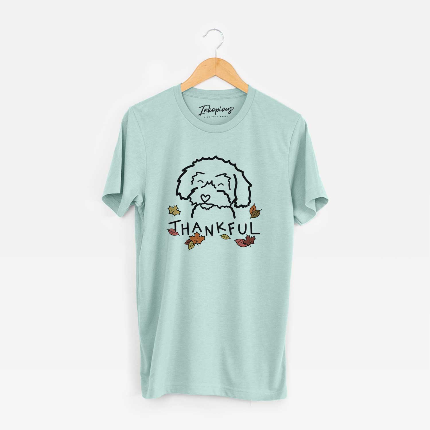 Minimalist line drawing of a Schnoodle with 'Thankful' lettering on a Heather Sage Unisex crewneck