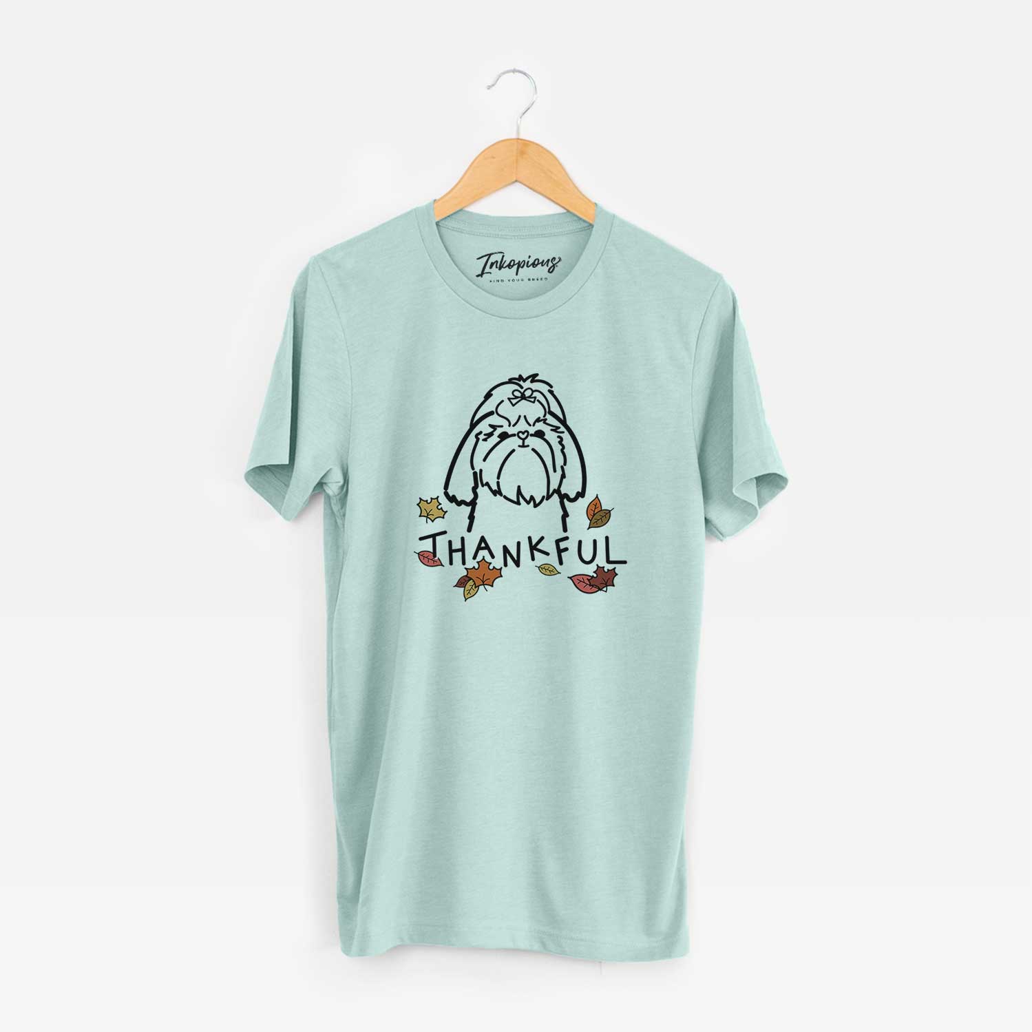 Minimalist line drawing of a Shih Tzu with 'Thankful' lettering on a Heather Sage Unisex crewneck