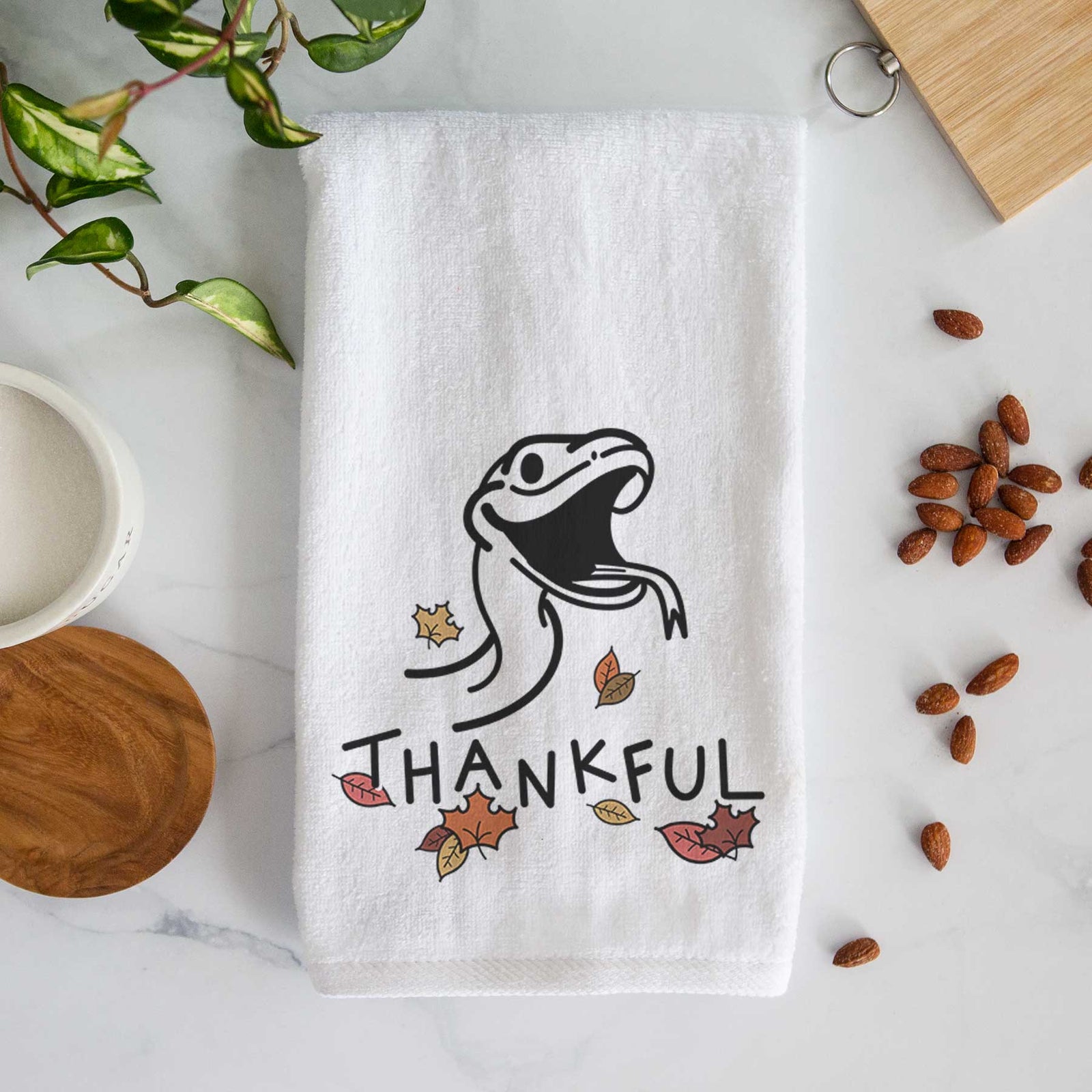 Minimalist line drawing of Spike the Snake with 'Thankful' lettering on a decorative hand towel