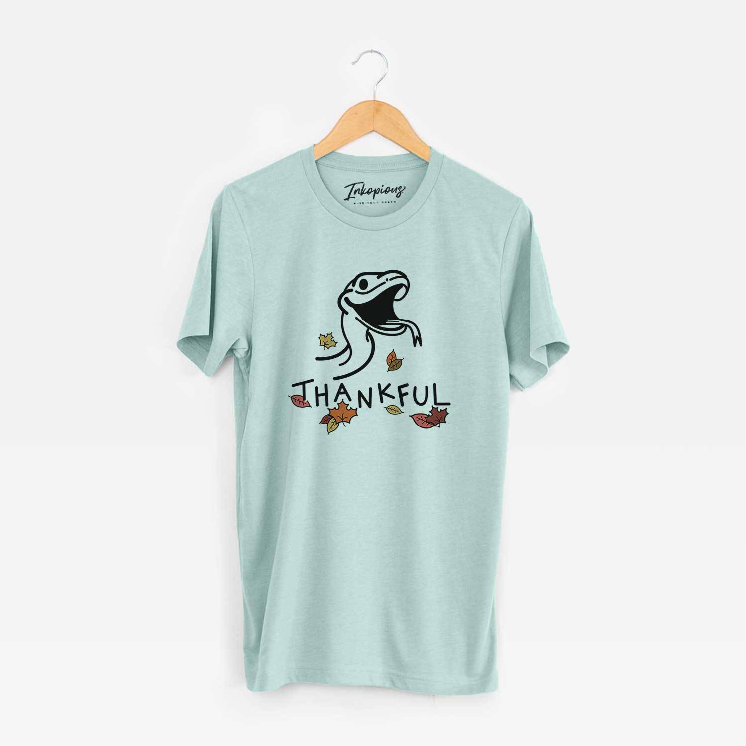 Minimalist line drawing of Spike the Snake with 'Thankful' lettering on a Heather Sage Unisex crewneck