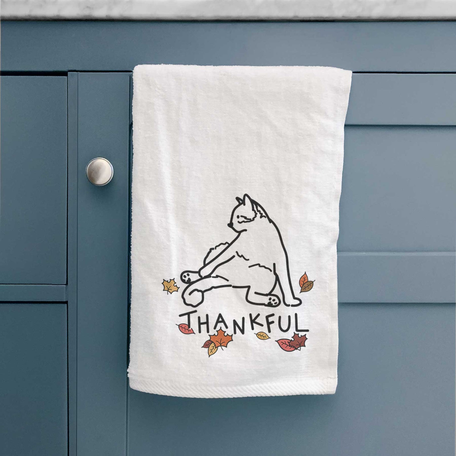 Minimalist line drawing of Tom the Cat with 'Thankful' lettering on a decorative hand towel