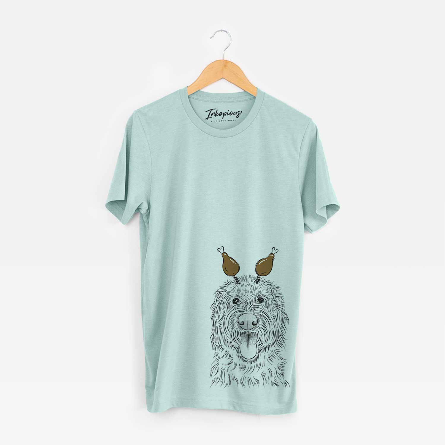 Hand-drawn sketch of Bennett the Doodle with a Thanksgiving turkey headpiece on a Heather Sage Unisex crewneck
