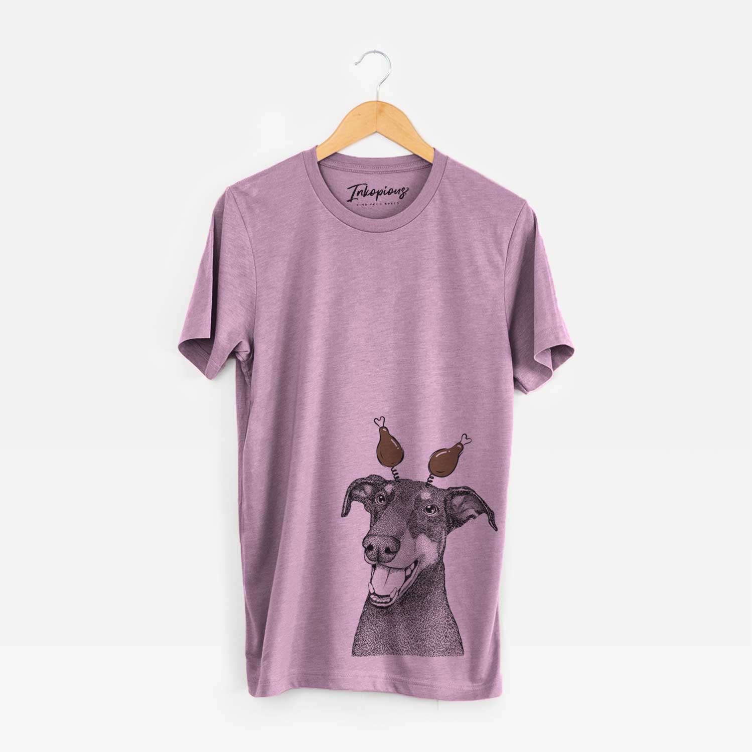Hand-drawn sketch of Bunnie the Doberman Pinscher with a Thanksgiving turkey headpiece on an Orchid Unisex crewneck
