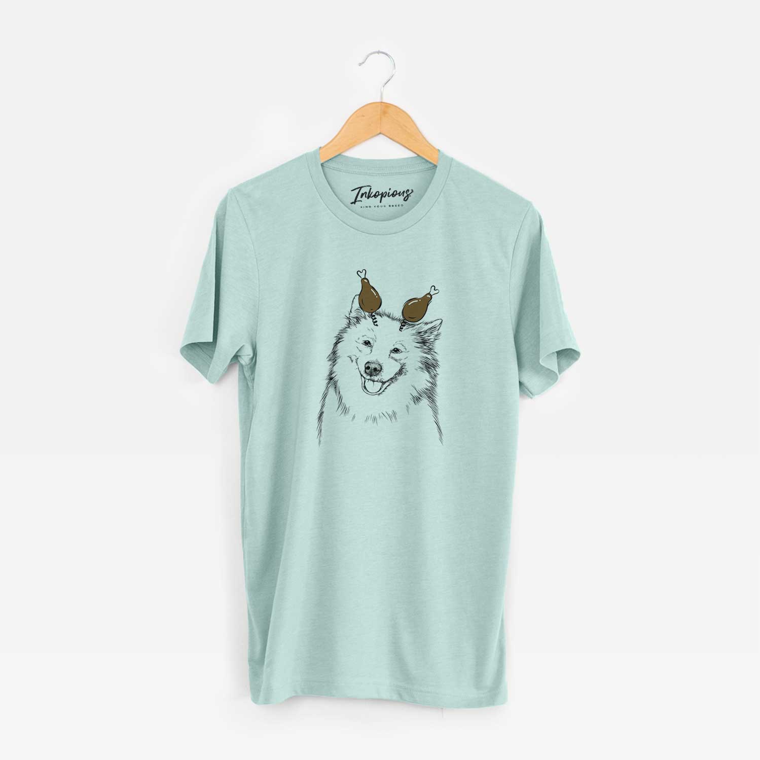 Hand-drawn sketch of Caico the Samoyed with a Thanksgiving turkey headpiece on a Heather Sage Unisex crewneck