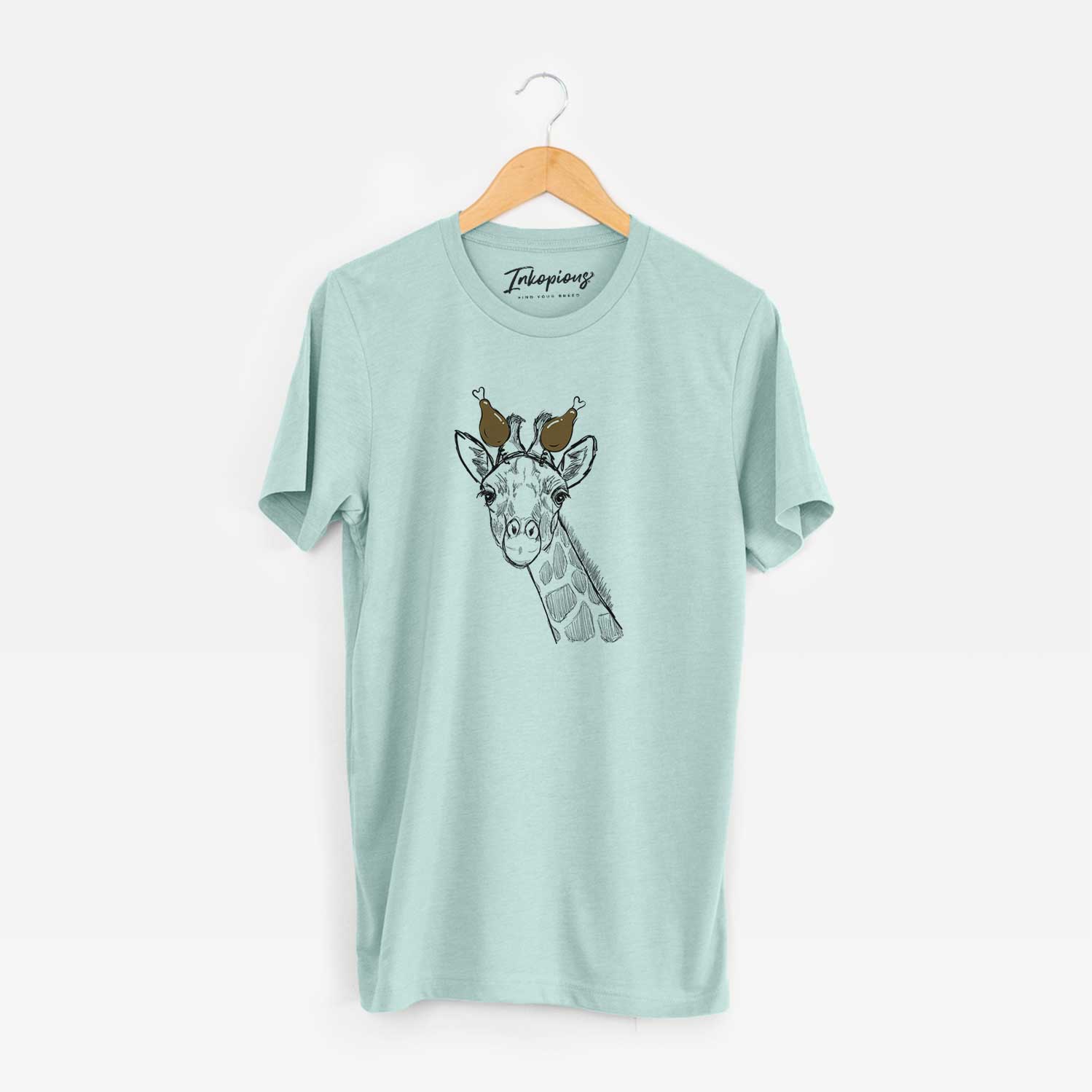 Hand-drawn sketch of Cedrick the Giraffe with a Thanksgiving turkey headpiece on a Heather Sage Unisex crewneck