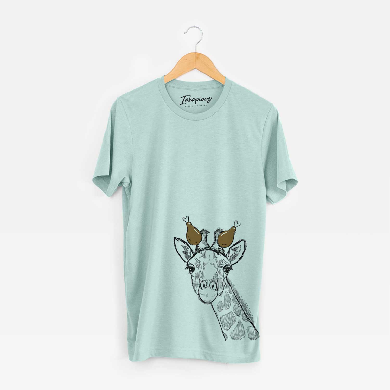 Hand-drawn sketch of Cedrick the Giraffe with a Thanksgiving turkey headpiece on a Heather Sage Unisex crewneck