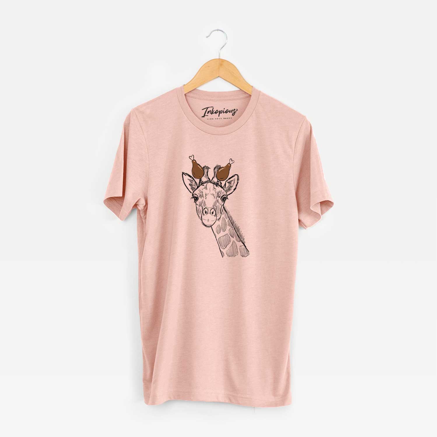 Hand-drawn sketch of Cedrick the Giraffe with a Thanksgiving turkey headpiece on a Peach Unisex crewneck