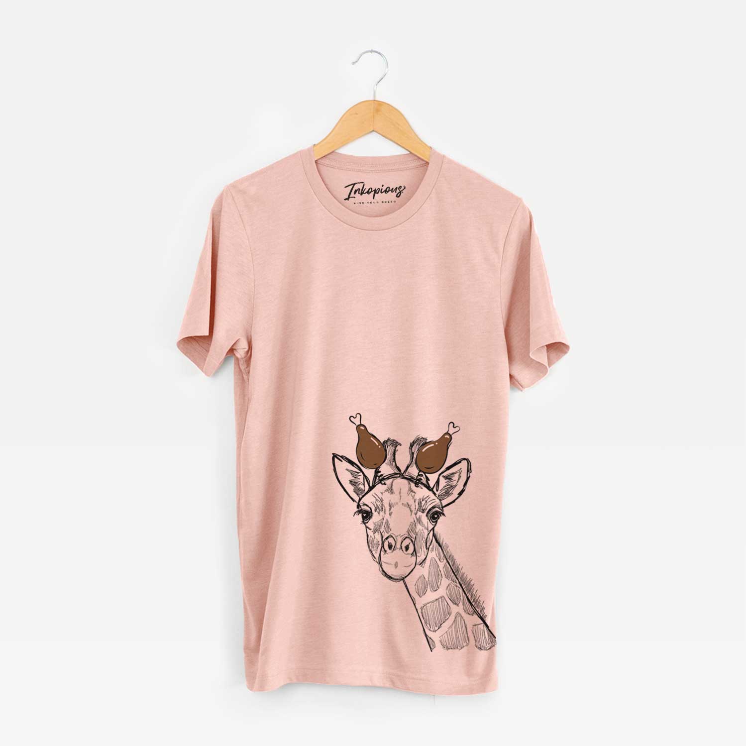 Hand-drawn sketch of Cedrick the Giraffe with a Thanksgiving turkey headpiece on a Peach Unisex crewneck