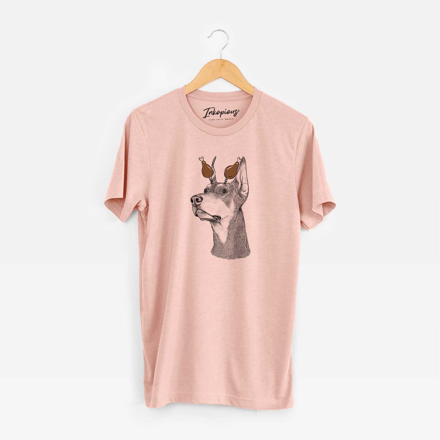 Hand-drawn sketch of Cenza the Doberman Pinscher with a Thanksgiving turkey headpiece on a Peach Unisex crewneck