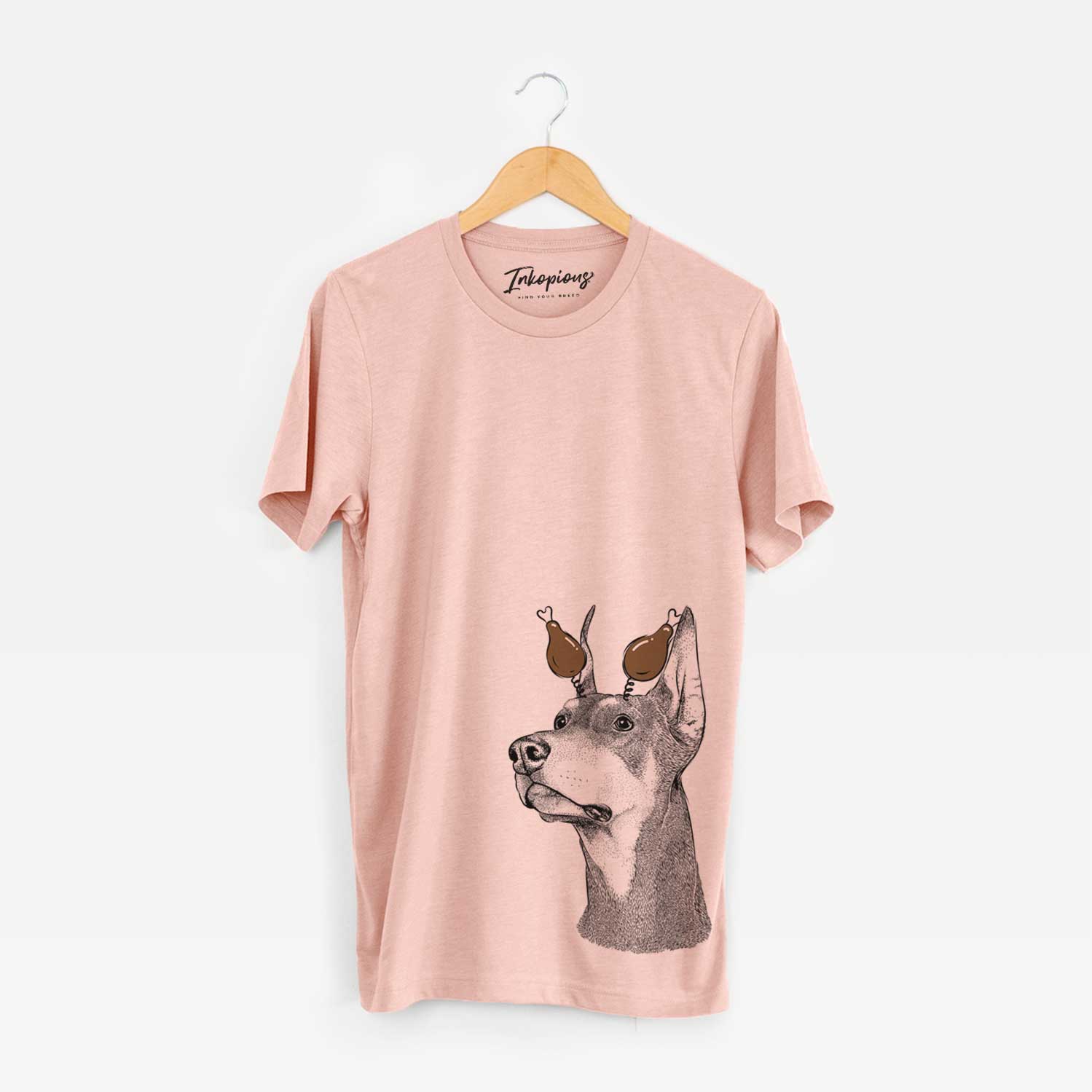 Hand-drawn sketch of Cenza the Doberman Pinscher with a Thanksgiving turkey headpiece on a Peach Unisex crewneck