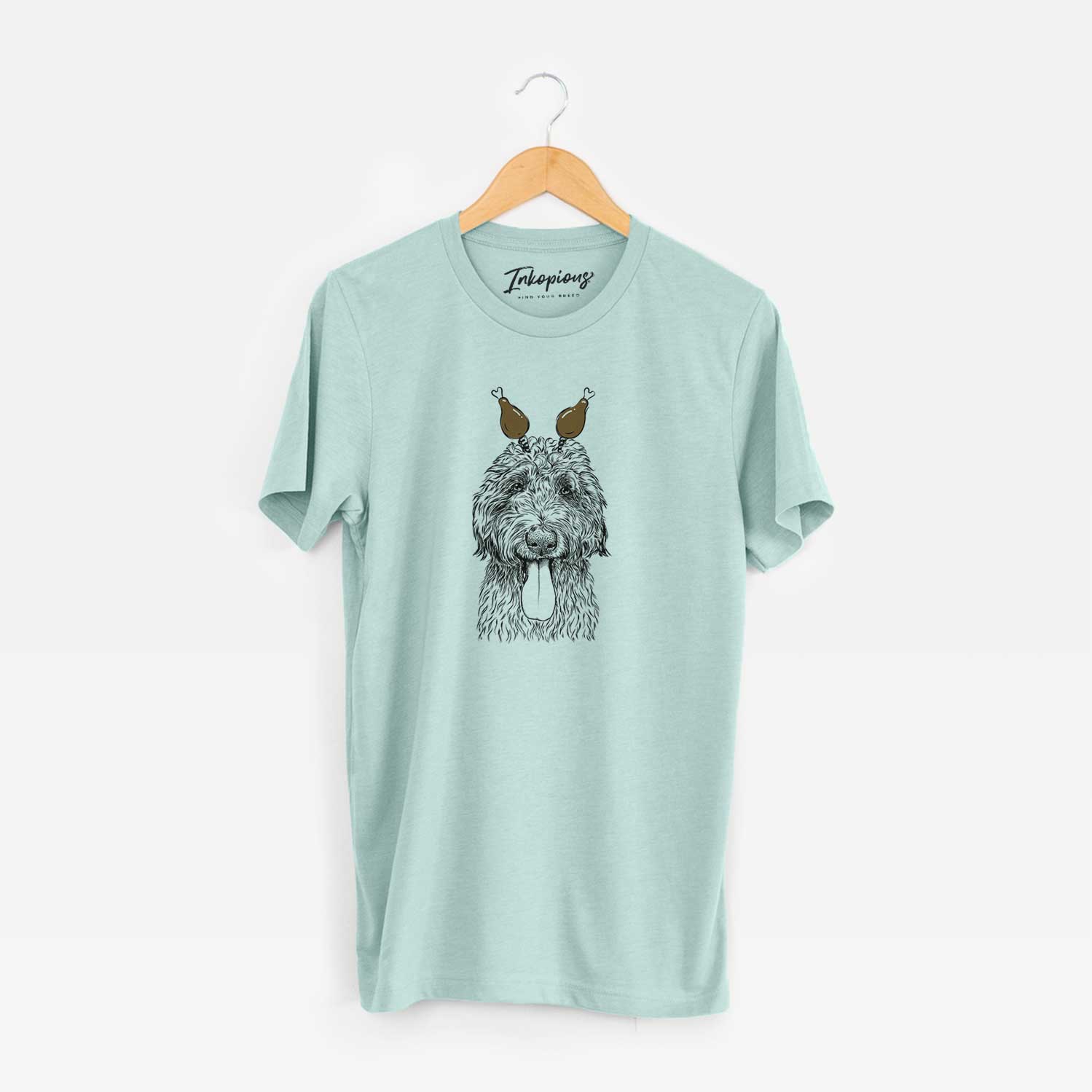Hand-drawn sketch of CiCi Paulk the Aussiedoodle with a Thanksgiving turkey headpiece on a Heather Sage Unisex crewneck