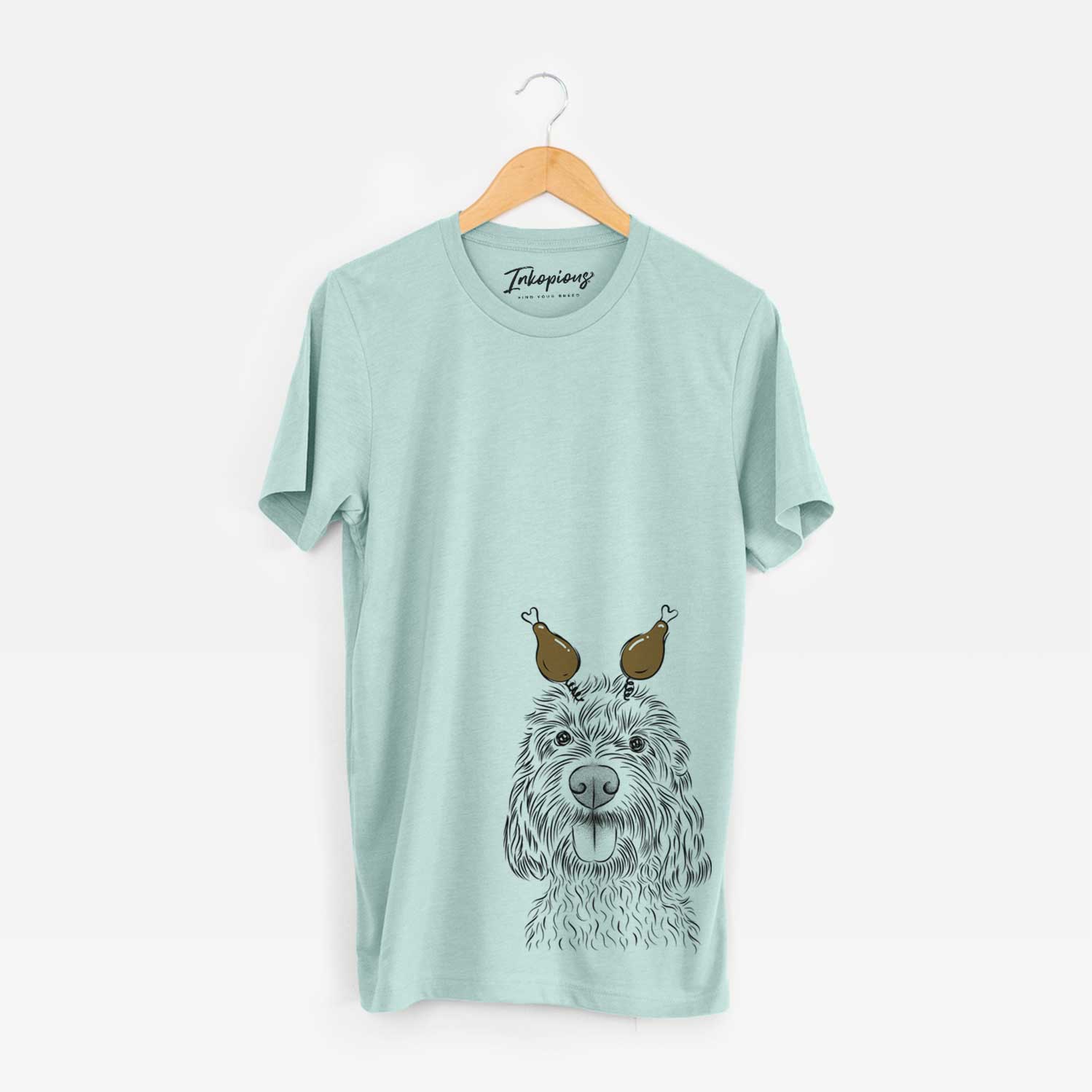 Hand-drawn sketch of Clover the Cockapoo with a Thanksgiving turkey headpiece on a Heather Sage Unisex crewneck