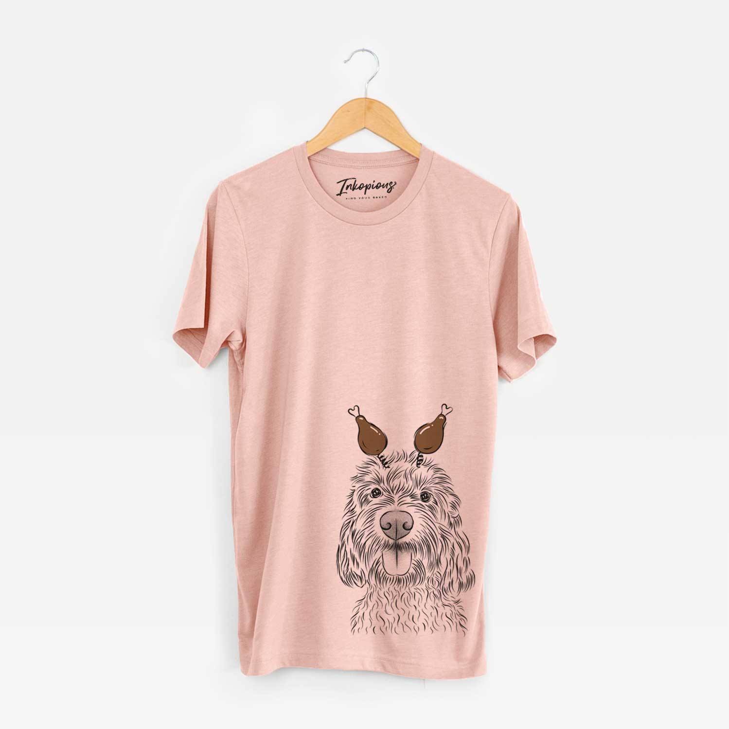 Hand-drawn sketch of Clover the Cockapoo with a Thanksgiving turkey headpiece on a Peach Unisex crewneck