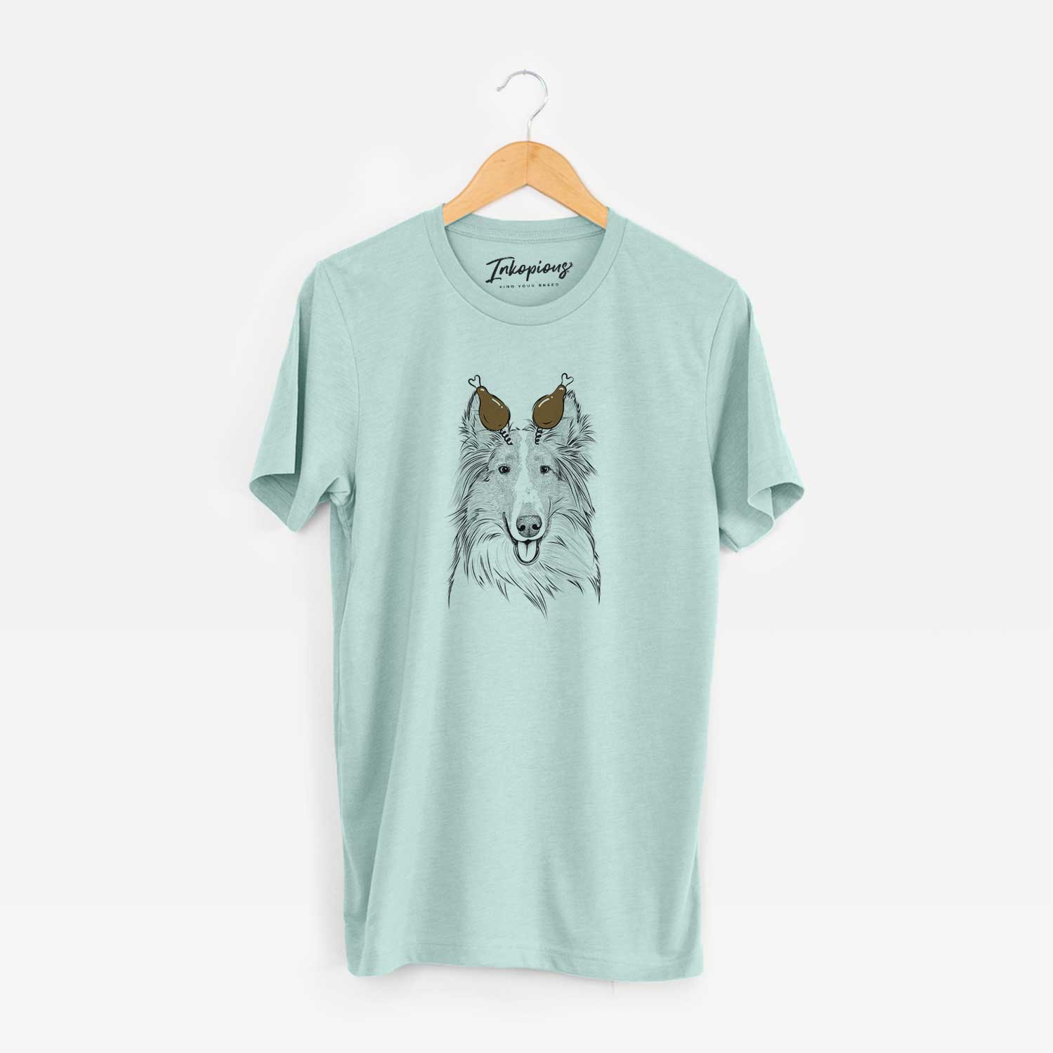 Hand-drawn sketch of Conrad the Rough Collie with a Thanksgiving turkey headpiece on a Heather Sage Unisex crewneck