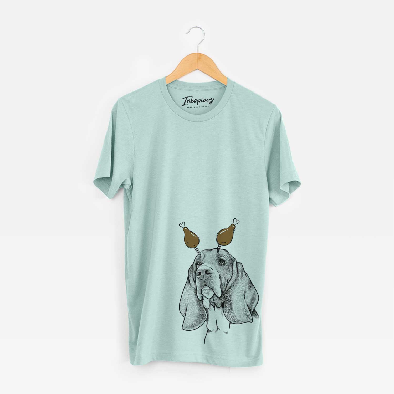 Hand-drawn sketch of Cooper the Basset Hound with a Thanksgiving turkey headpiece on a Heather Sage Unisex crewneck