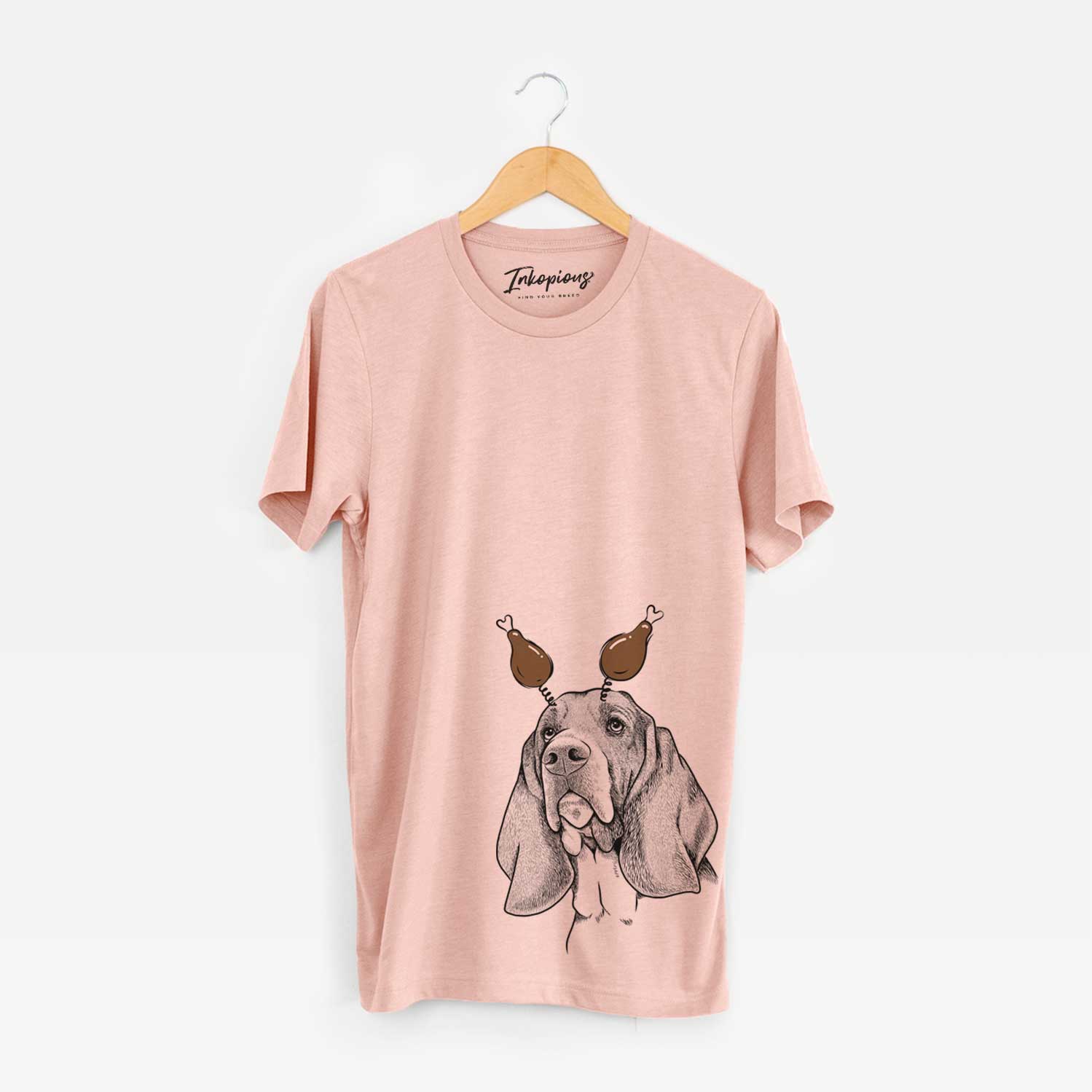 Hand-drawn sketch of Cooper the Basset Hound with a Thanksgiving turkey headpiece on a Peach Unisex crewneck