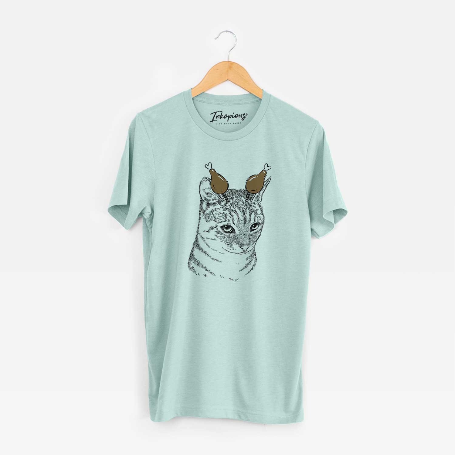 Hand-drawn sketch of Dora the Tabby Cat with a Thanksgiving turkey headpiece on a Heather Sage Unisex crewneck