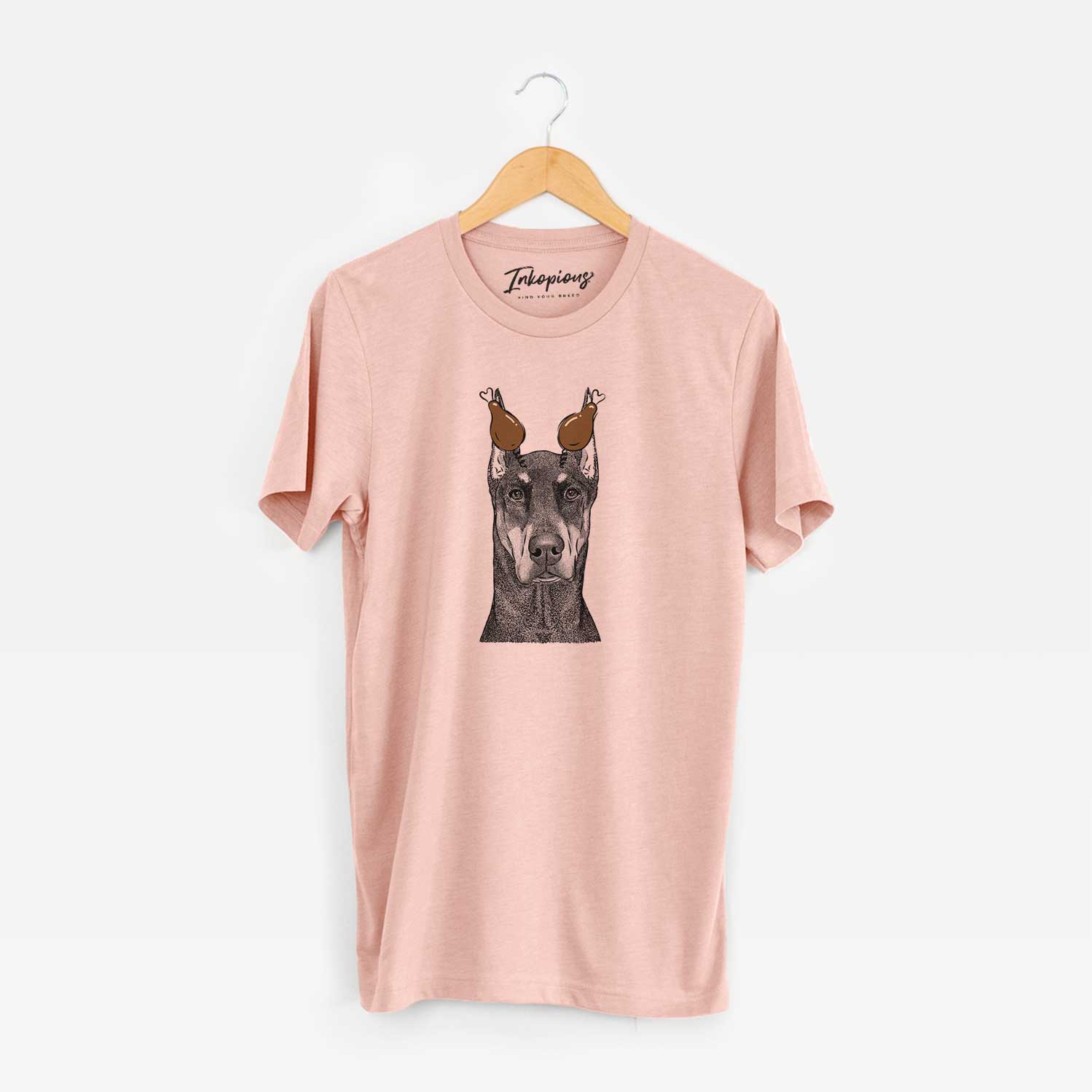 Hand-drawn sketch of Drake the Doberman Pinscher with a Thanksgiving turkey headpiece on a Peach Unisex crewneck