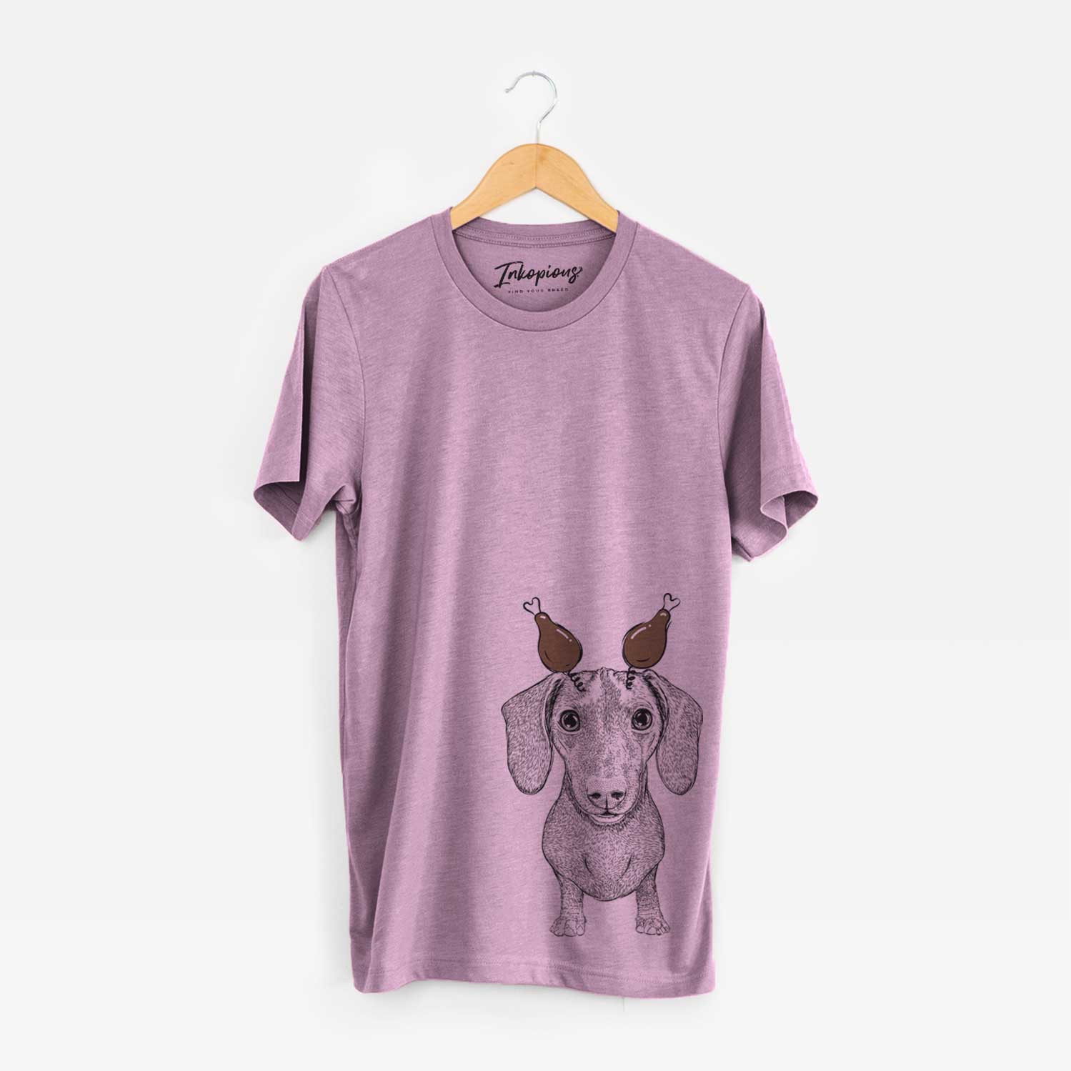 Hand-drawn sketch of Ernie the Mini Dachshund with a Thanksgiving turkey headpiece on an Orchid Unisex crewneck