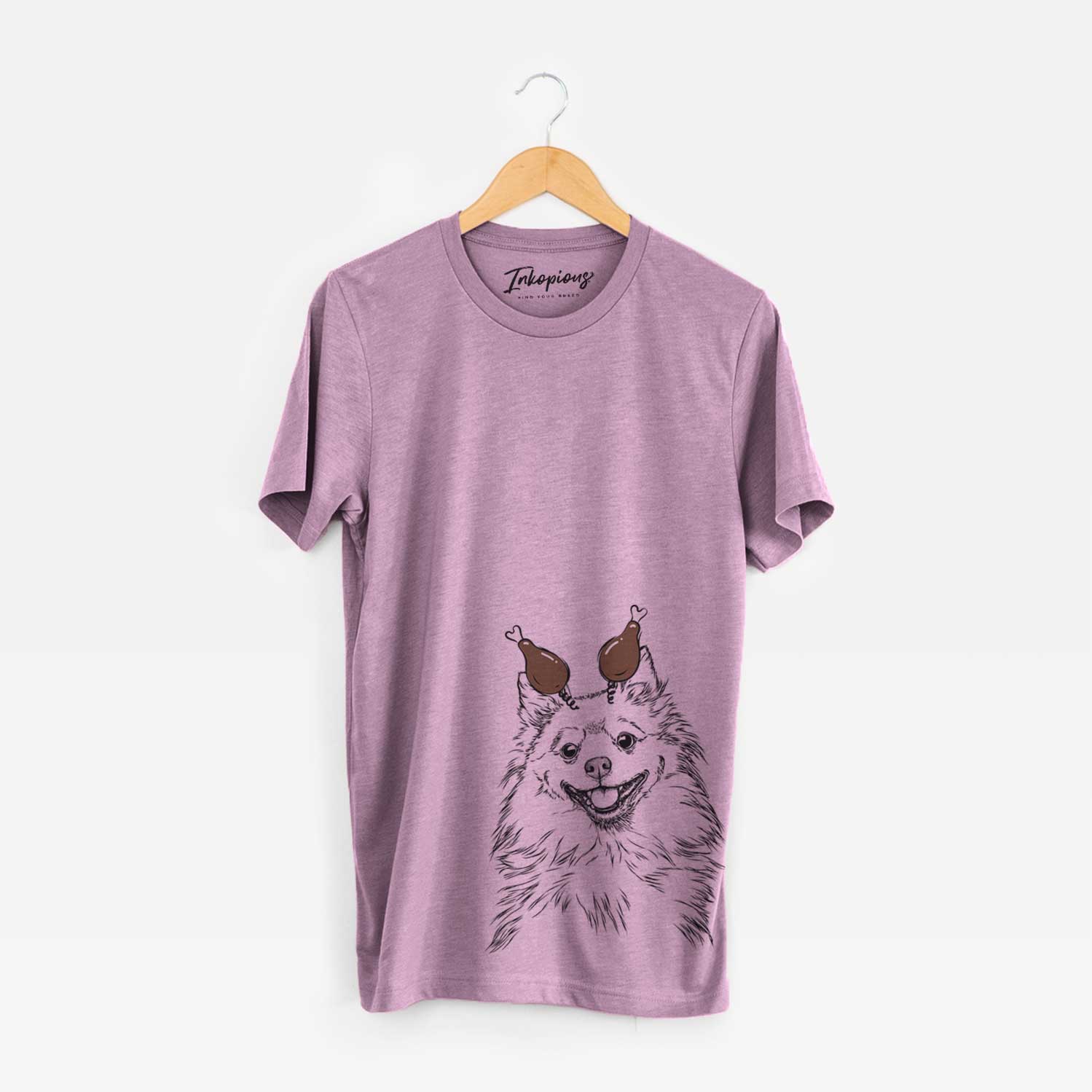 Hand-drawn sketch of Fibi the Spitz with a Thanksgiving turkey headpiece on an Orchid Unisex crewneck