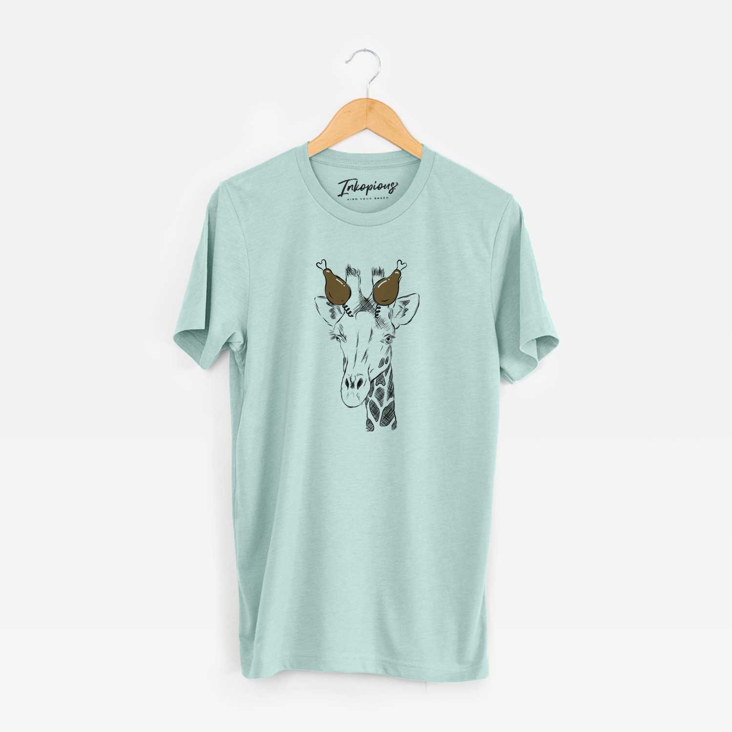 Hand-drawn sketch of Geoffrey the Giraffe with a Thanksgiving turkey headpiece on a Heather Sage Unisex crewneck