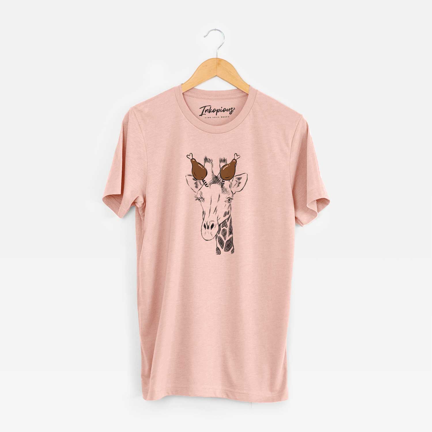 Hand-drawn sketch of Geoffrey the Giraffe with a Thanksgiving turkey headpiece on a Peach Unisex crewneck