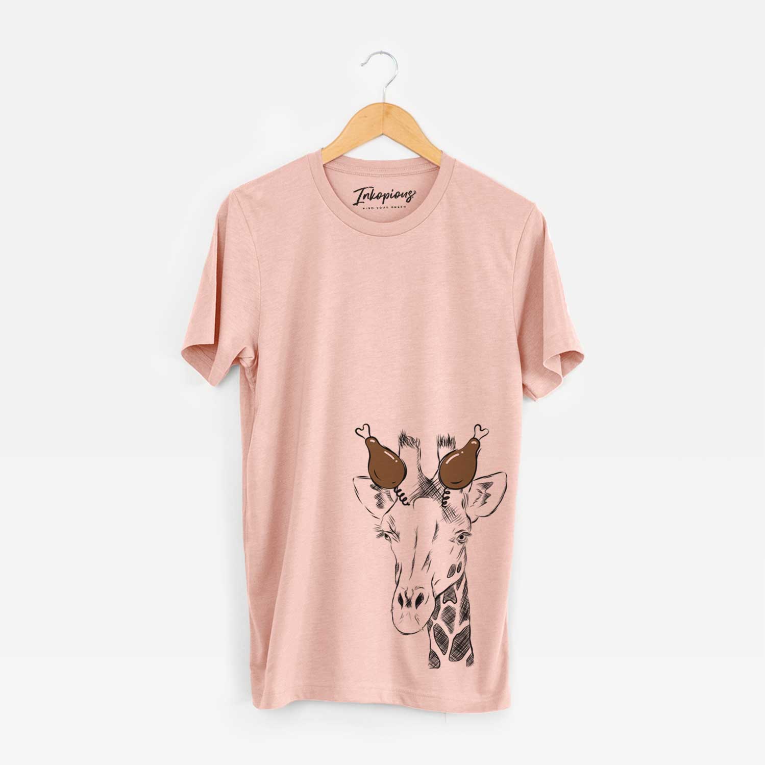 Hand-drawn sketch of Geoffrey the Giraffe with a Thanksgiving turkey headpiece on a Peach Unisex crewneck