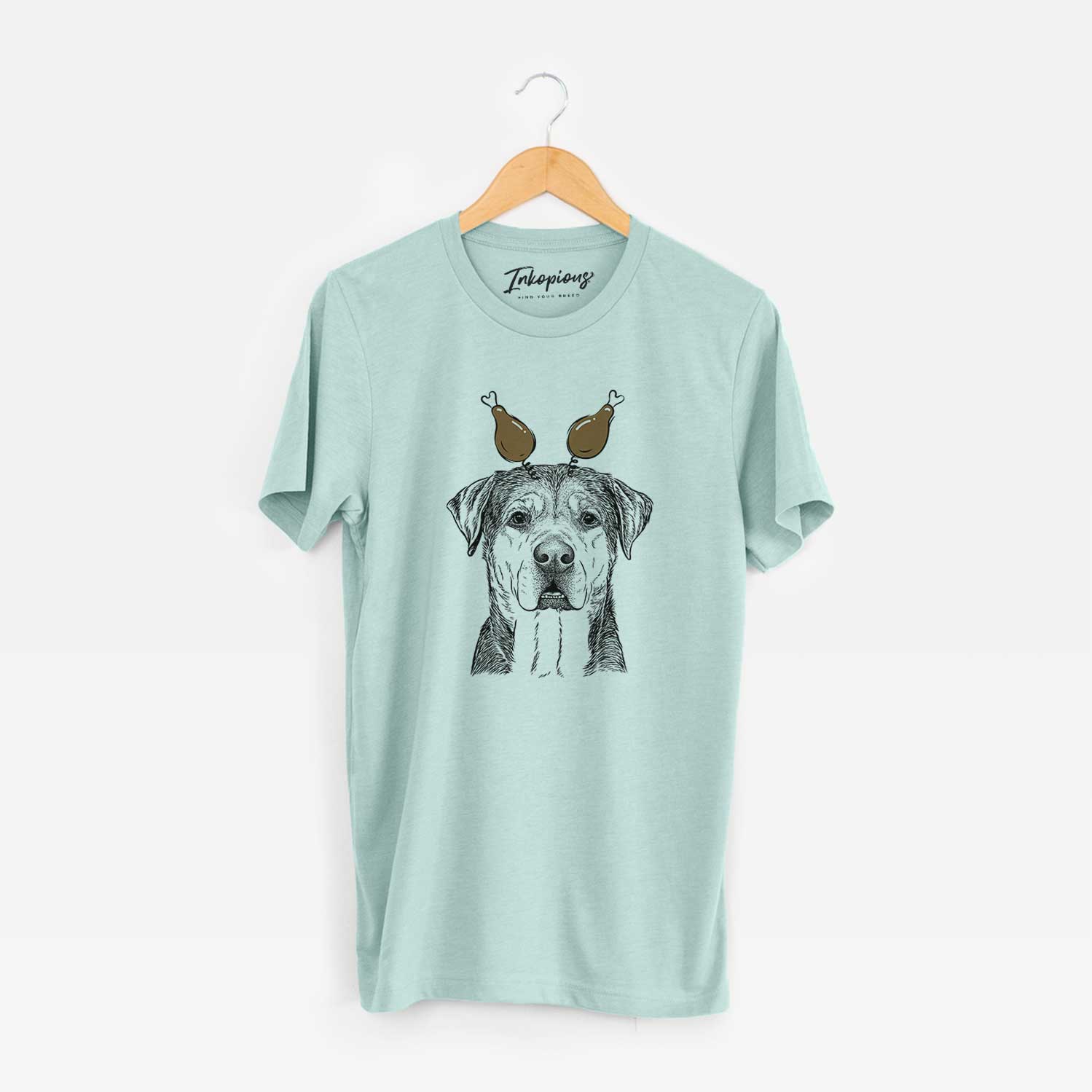 Hand-drawn sketch of Gus the Rottweiler Mix with a Thanksgiving turkey headpiece on a Heather Sage Unisex crewneck