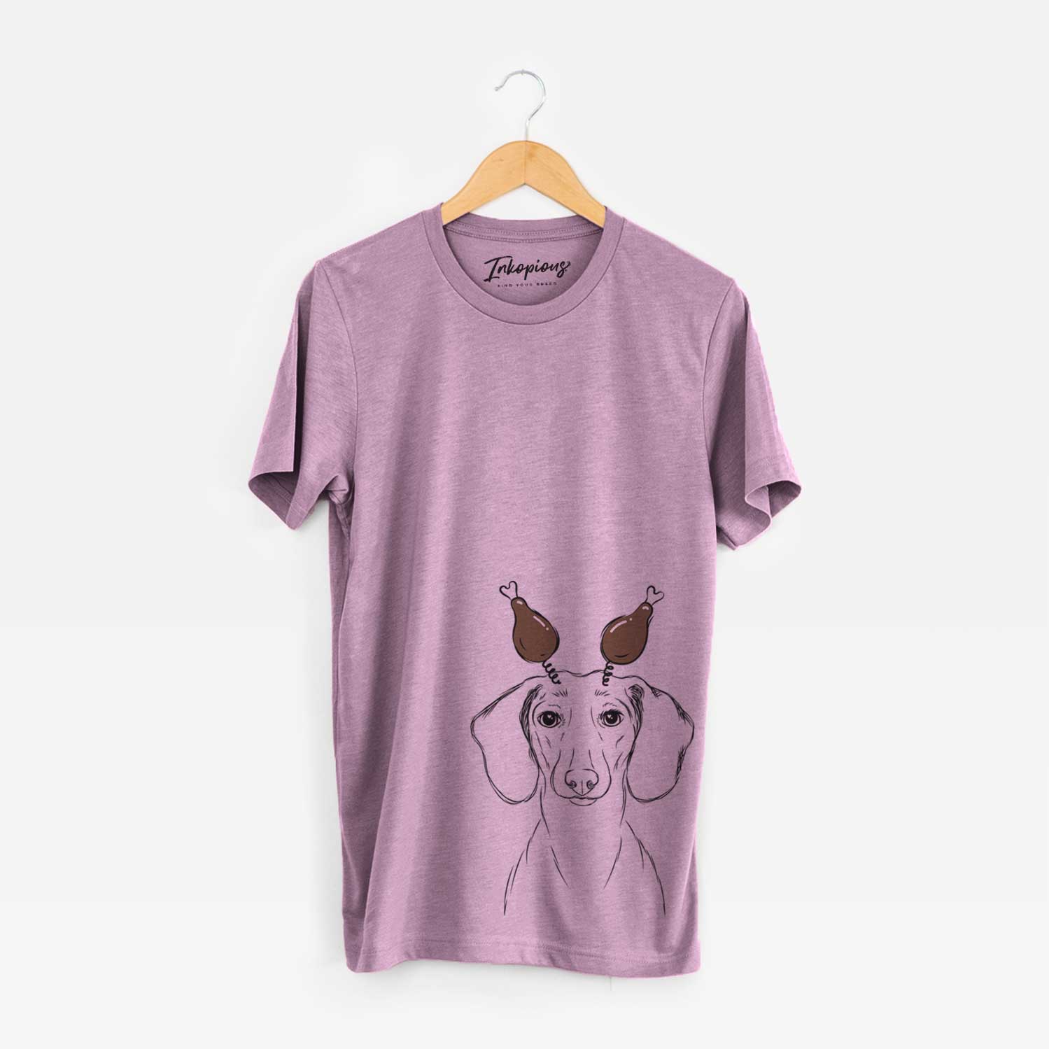 Hand-drawn sketch of Hans the Dachshund with a Thanksgiving turkey headpiece on an Orchid Unisex crewneck