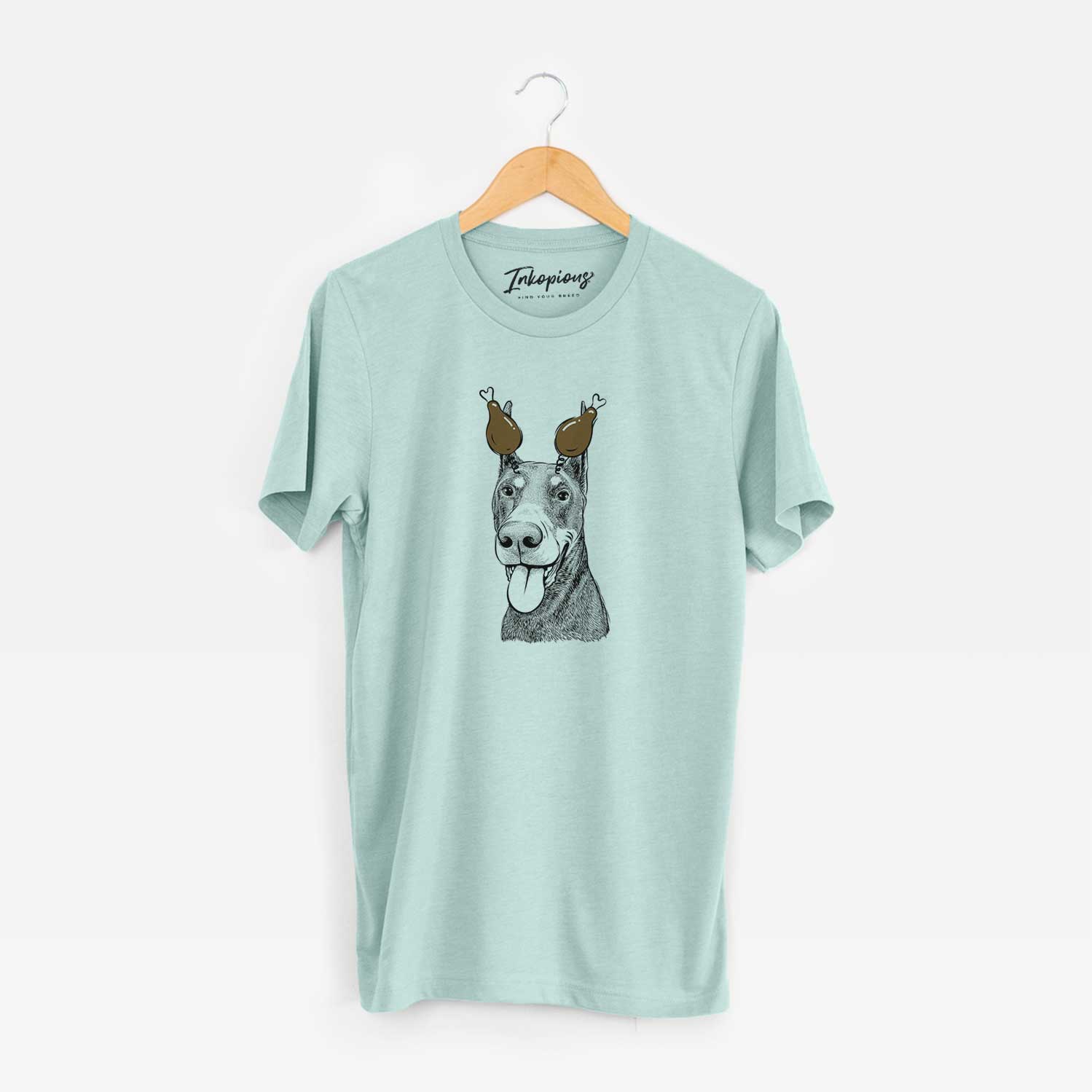 Hand-drawn sketch of Happy Sunny the Doberman Pinscher with a Thanksgiving turkey headpiece on a Heather Sage Unisex crewneck