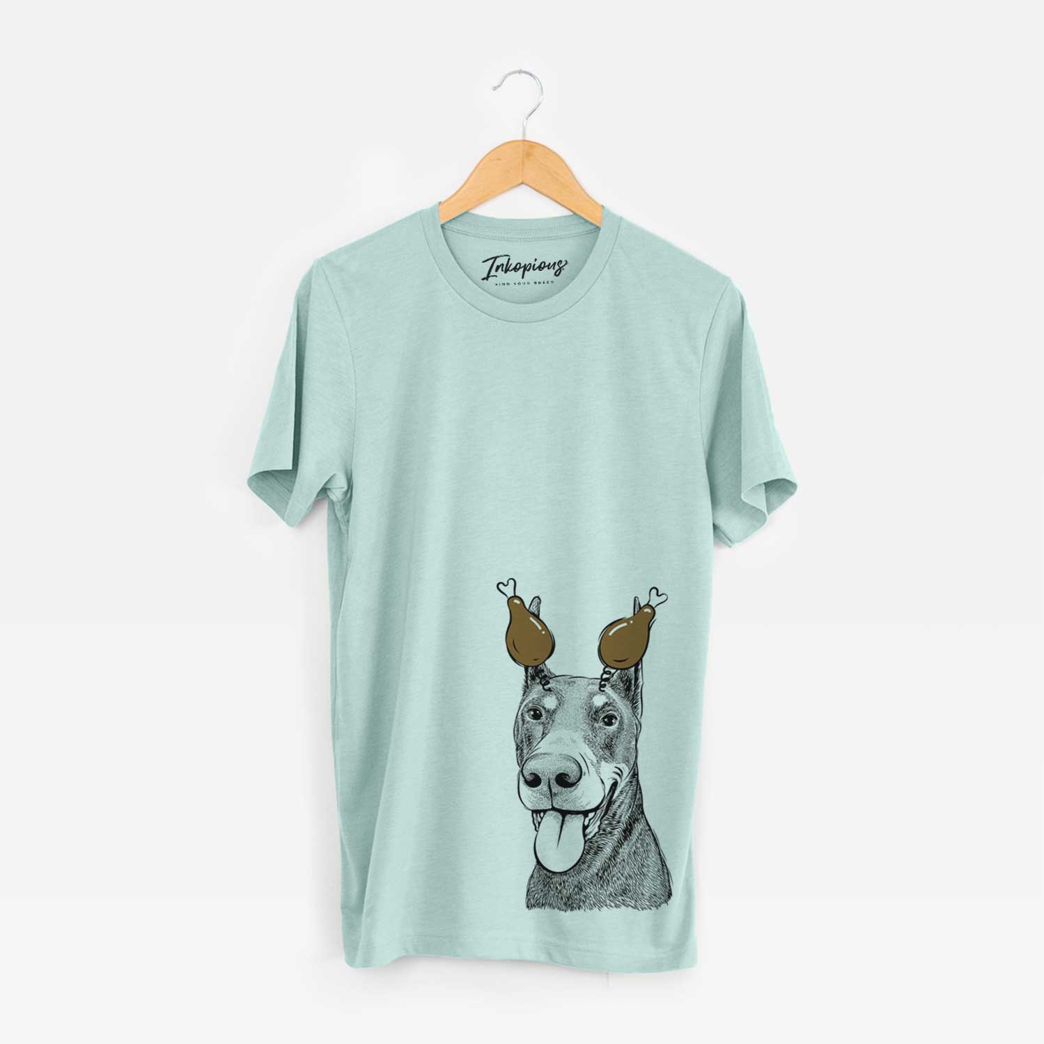 Hand-drawn sketch of Happy Sunny the Doberman Pinscher with a Thanksgiving turkey headpiece on a Heather Sage Unisex crewneck